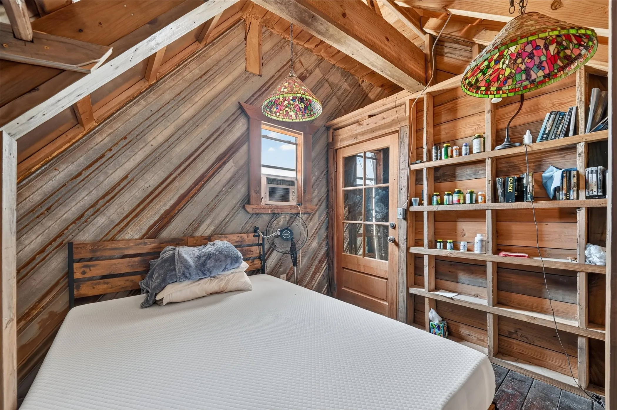Wood-paneled interior with exposed beam ceiling and built-in shelving