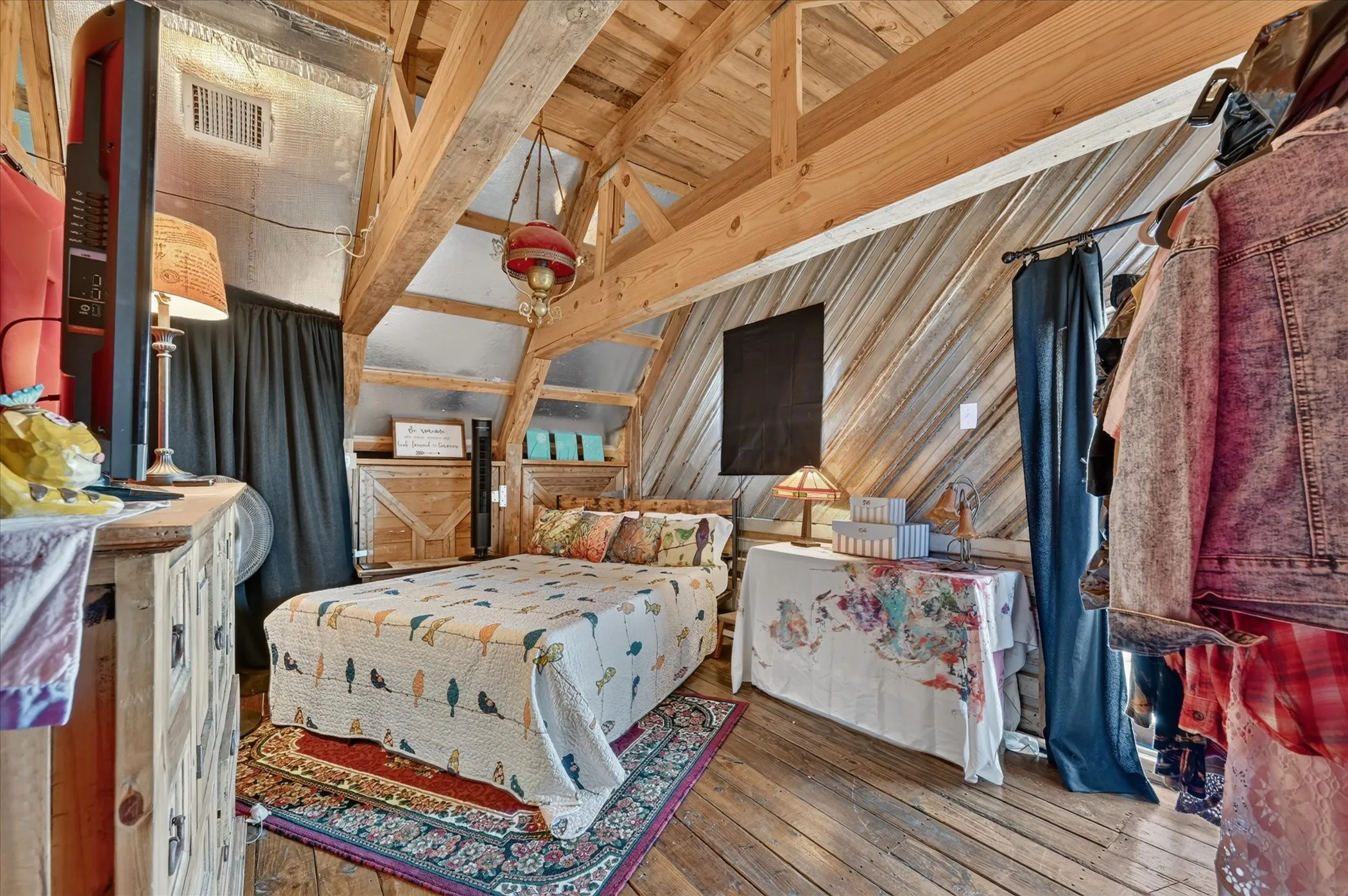 Vaulted wood-paneled ceiling, exposed wooden beams, wood-finish flooring, and wooden built-in shelving
