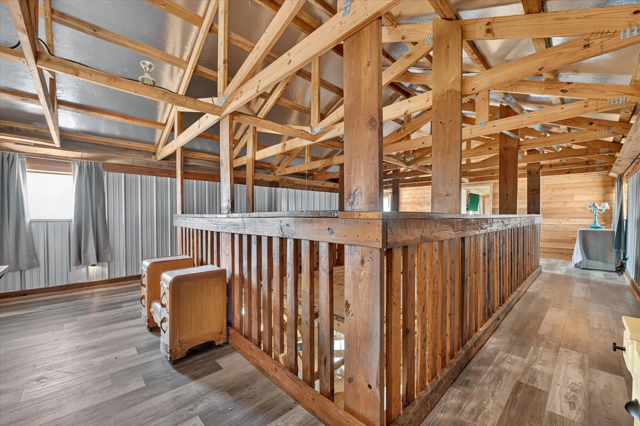 Exposed wood beam ceiling, wood finish flooring, wood railing, wood plank wall, and metal wall siding
