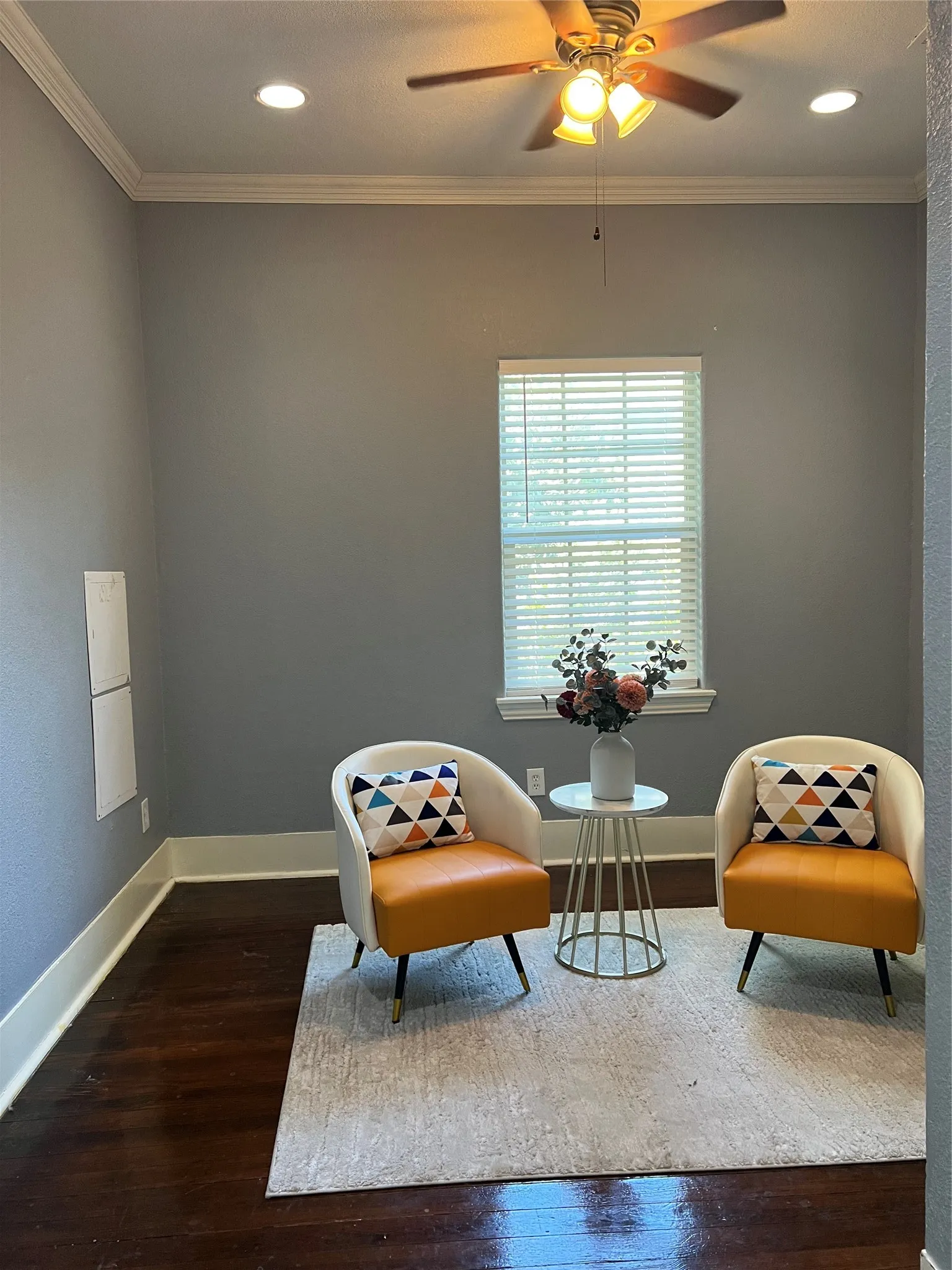 Dark wood-finish flooring, crown molding, recessed lighting, ceiling fan with light fixture, and window with blinds