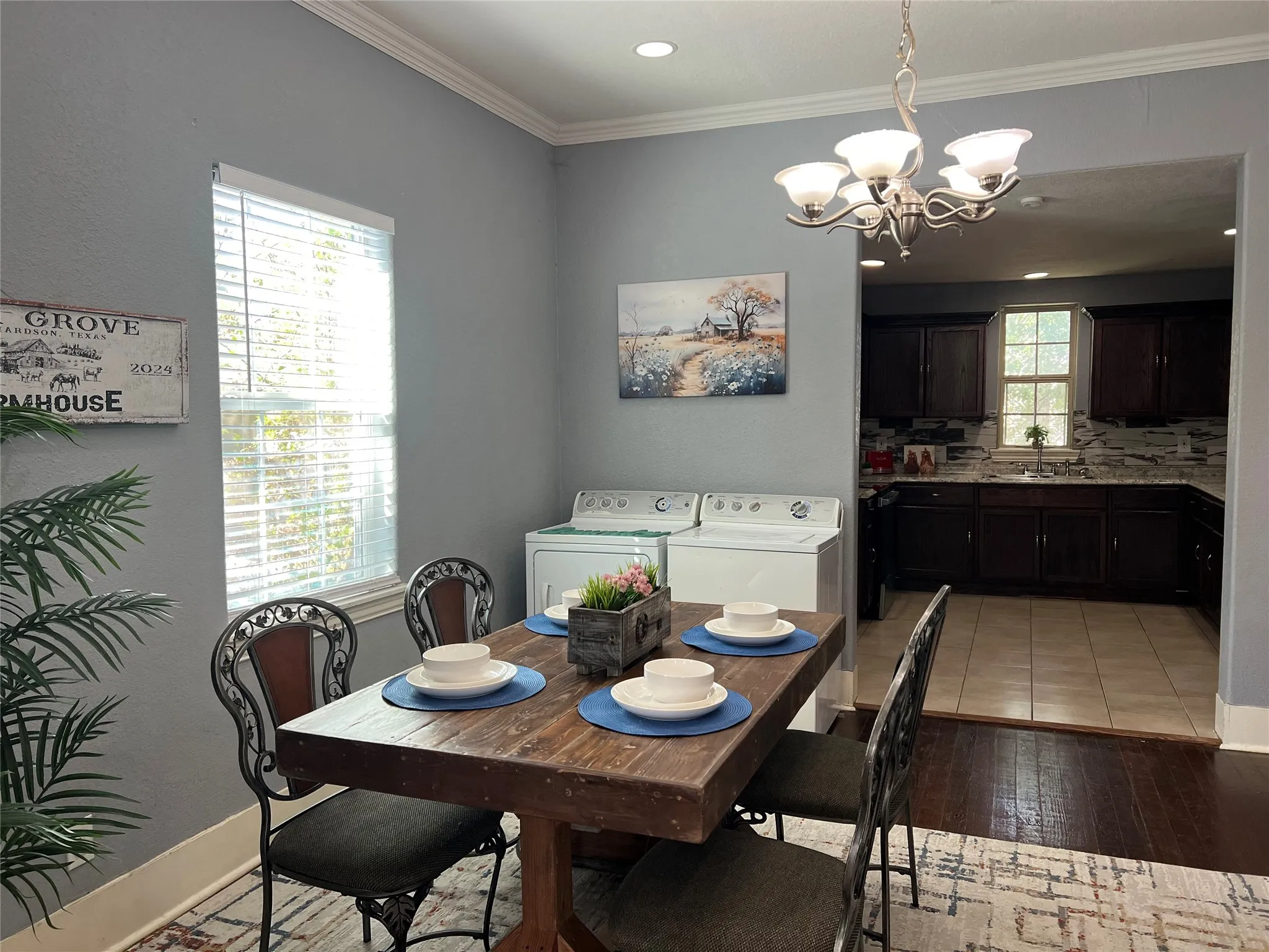 Dining area featuring wood-finish flooring, crown molding, and a chandelier