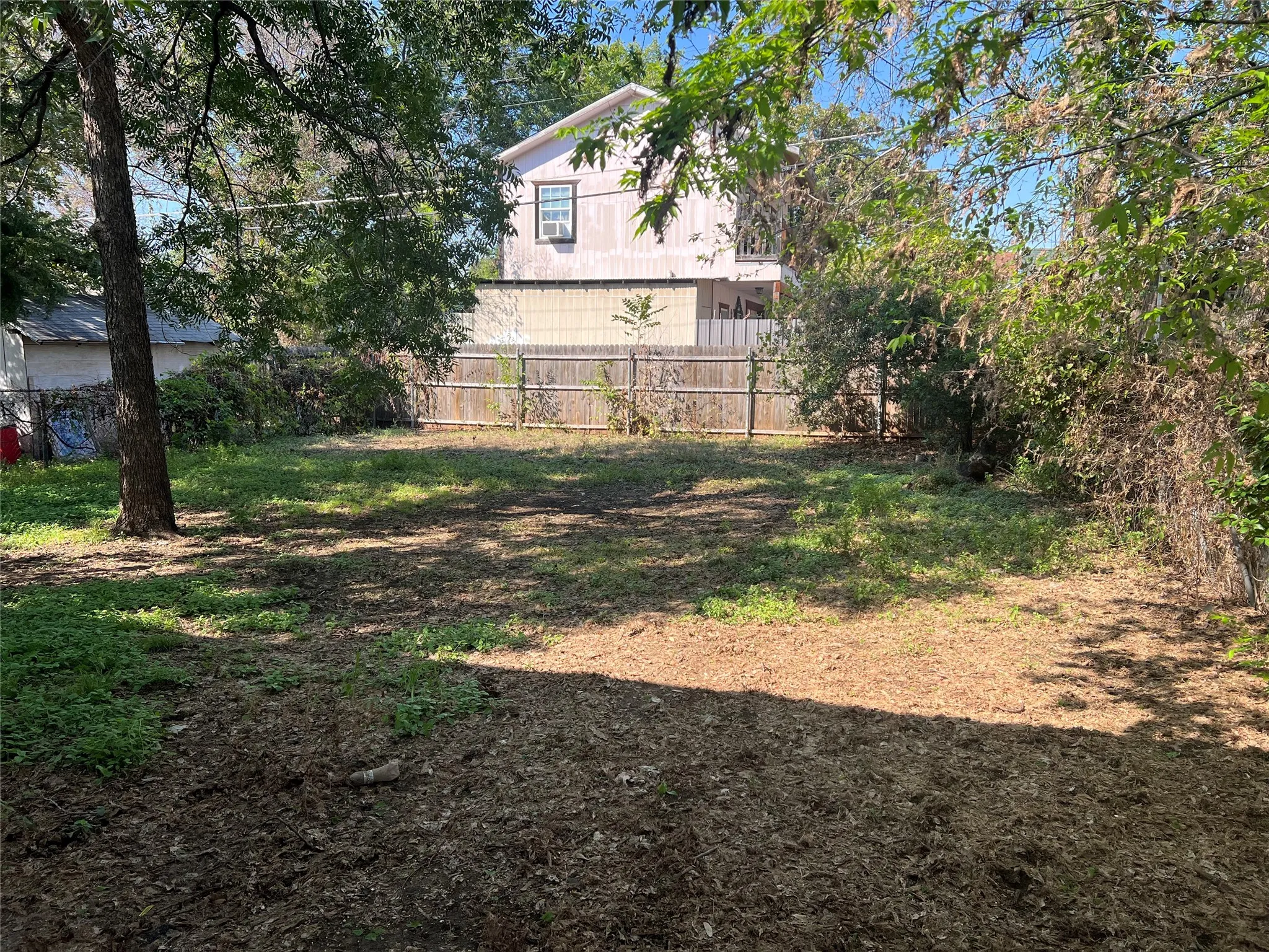 Expansive property lot featuring mature trees and wood fencing