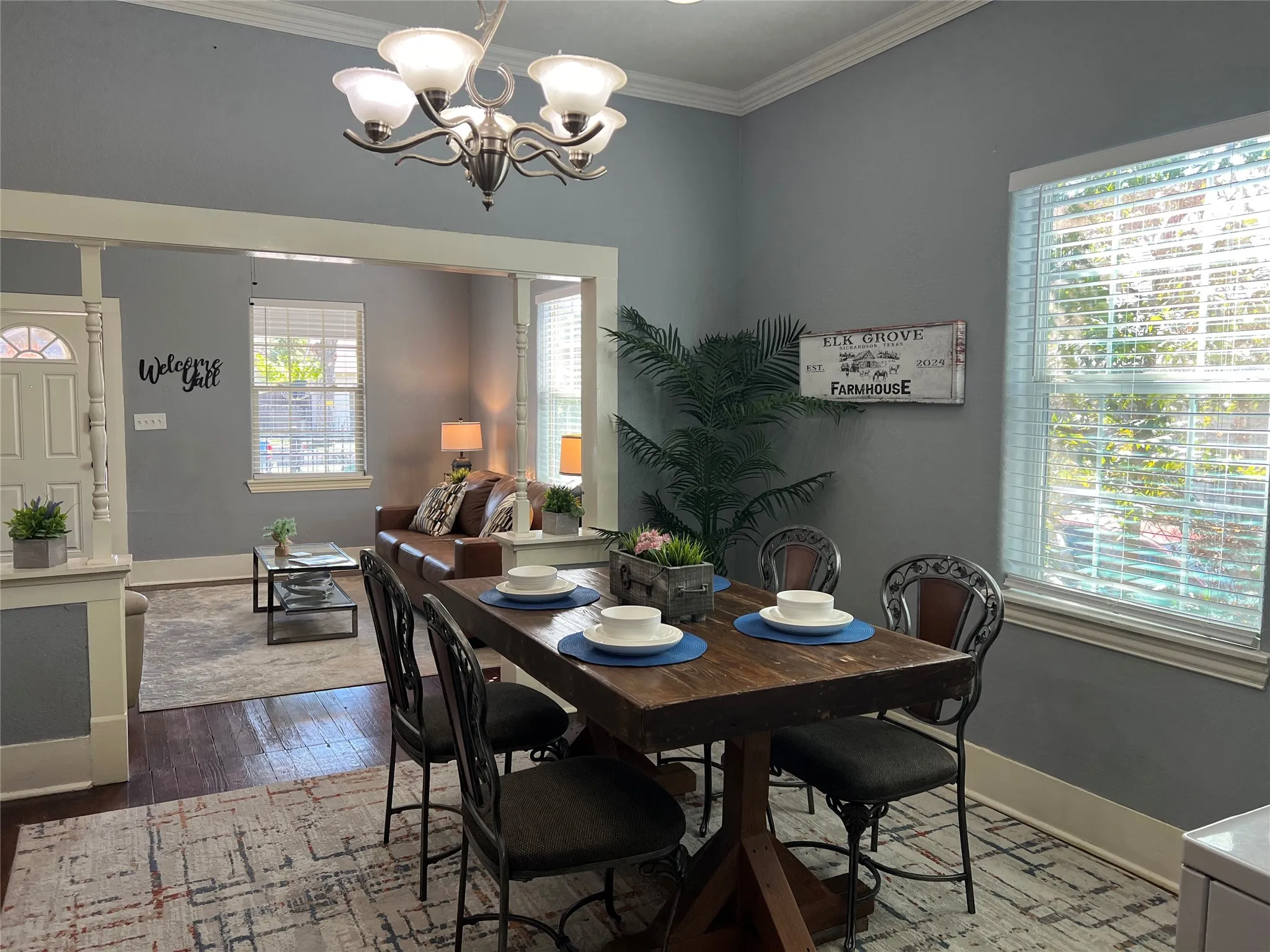 Crown molding, recessed lighting, and a chandelier illuminate the dining area