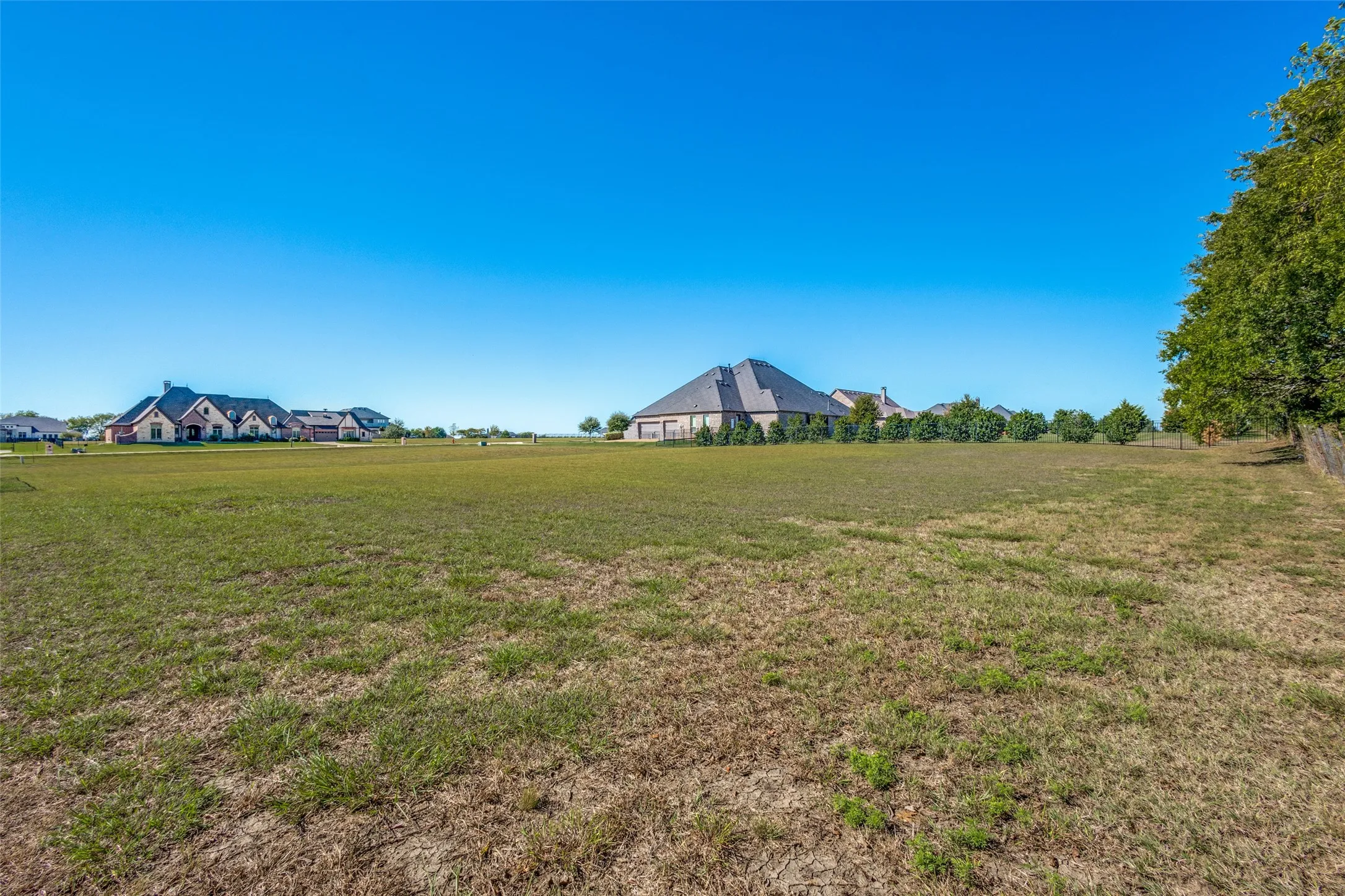 Expansive level lot with established perimeter trees and partially visible fencing