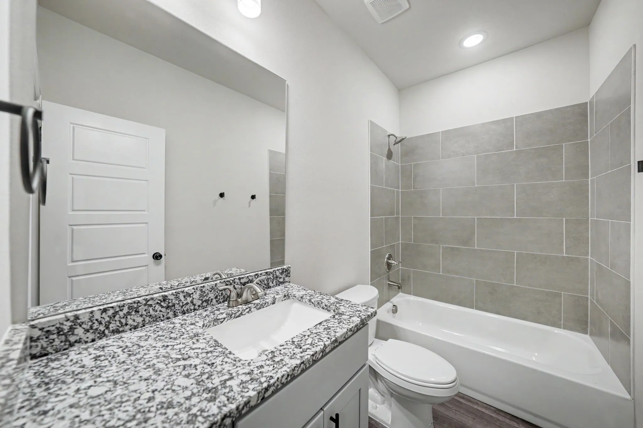 Vanity with granite countertop, integrated sink, and brushed nickel faucet