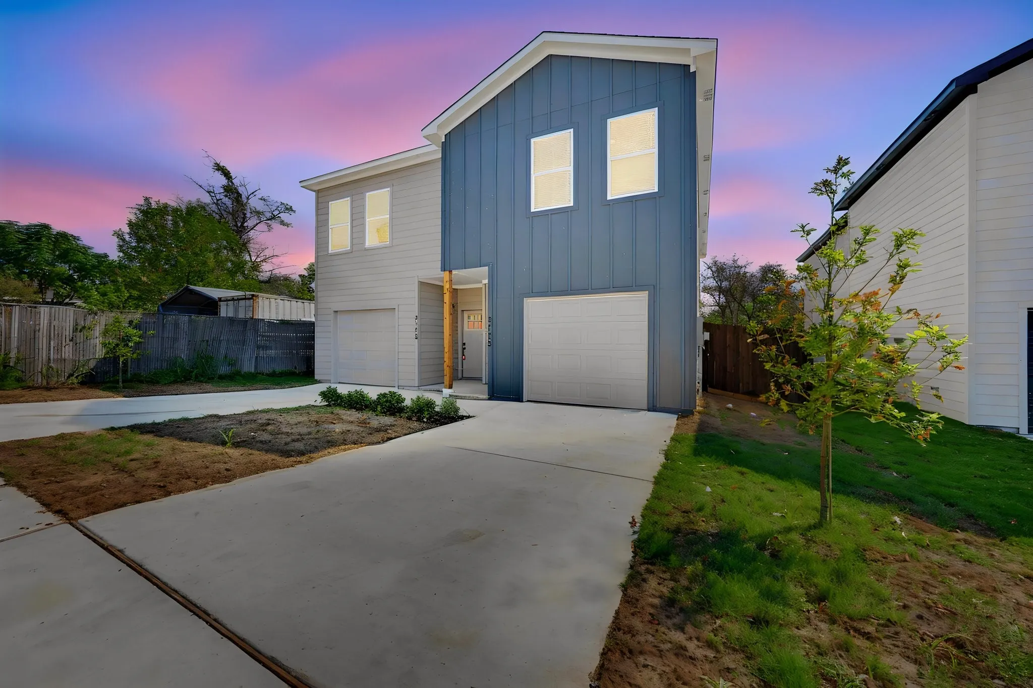 Modern exterior featuring vertical siding, a two-car garage, and concrete driveway