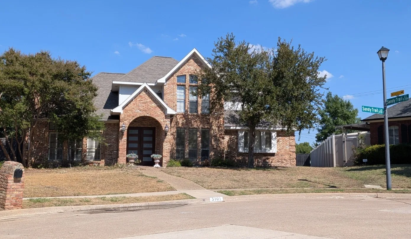 Brick exterior with stone accents, arched entry, and a prominent front gable