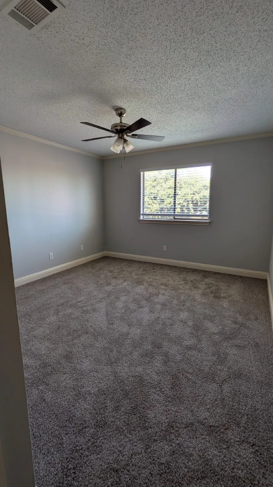 Recessed window, ceiling fan with integrated lighting, textured ceiling, and crown molding