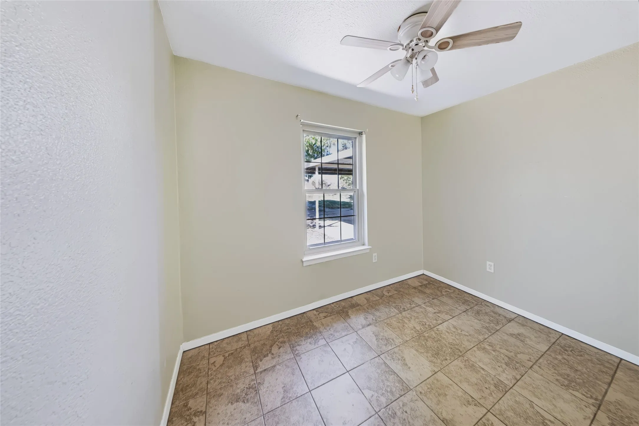 Main Home – Neutral-toned walls, tile flooring, and a window with natural light