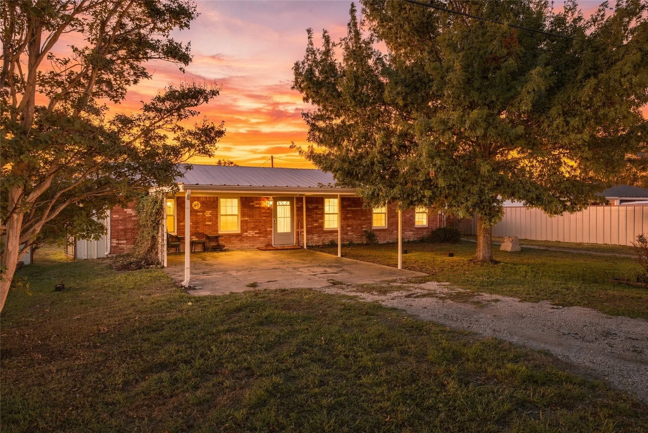 Main Home – Brick exterior residence with a covered carport and a metal roof