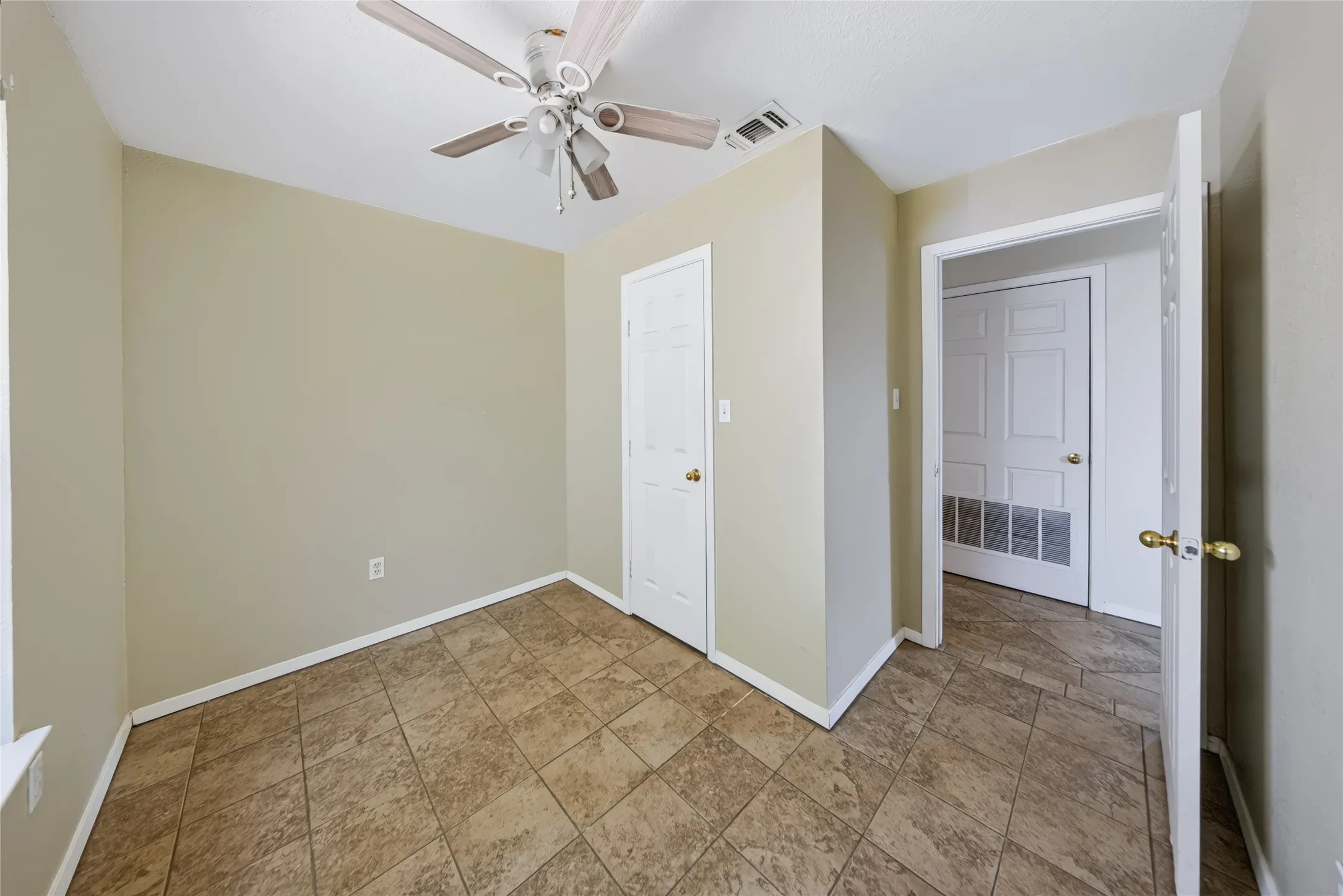 Main Home – Tile flooring, white paneled doors, ceiling fan with light fixture, and neutral wall paint
