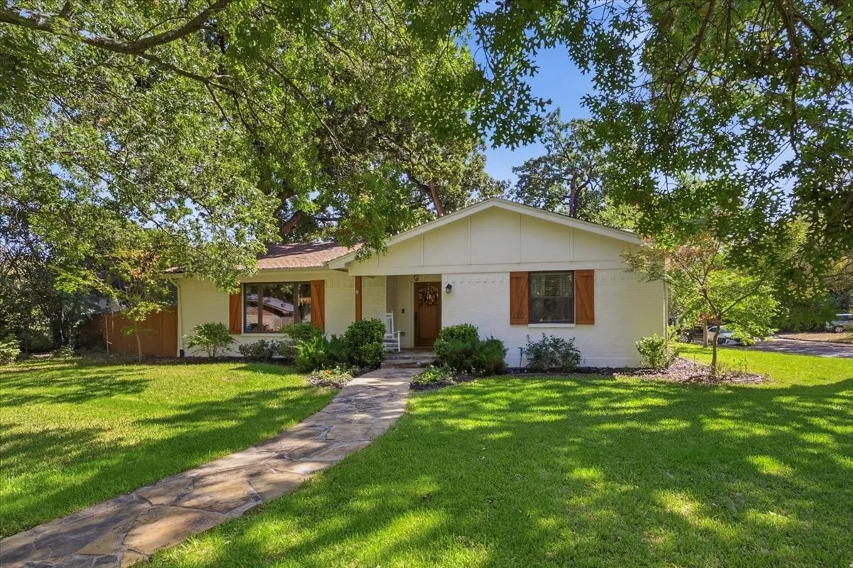 Gorgeously landscaped and shaded by towering trees.