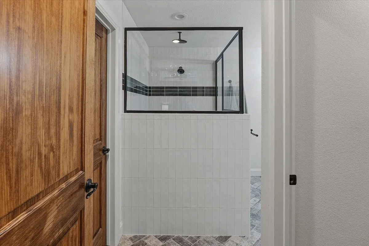 Walk in shower with glass enclosure.