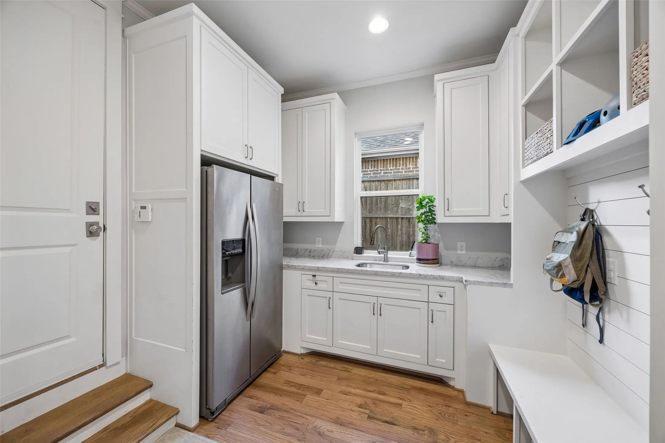 Oversized mudroom with plenty of storage, a separate refrigerator and sink. Direct access to the garage.