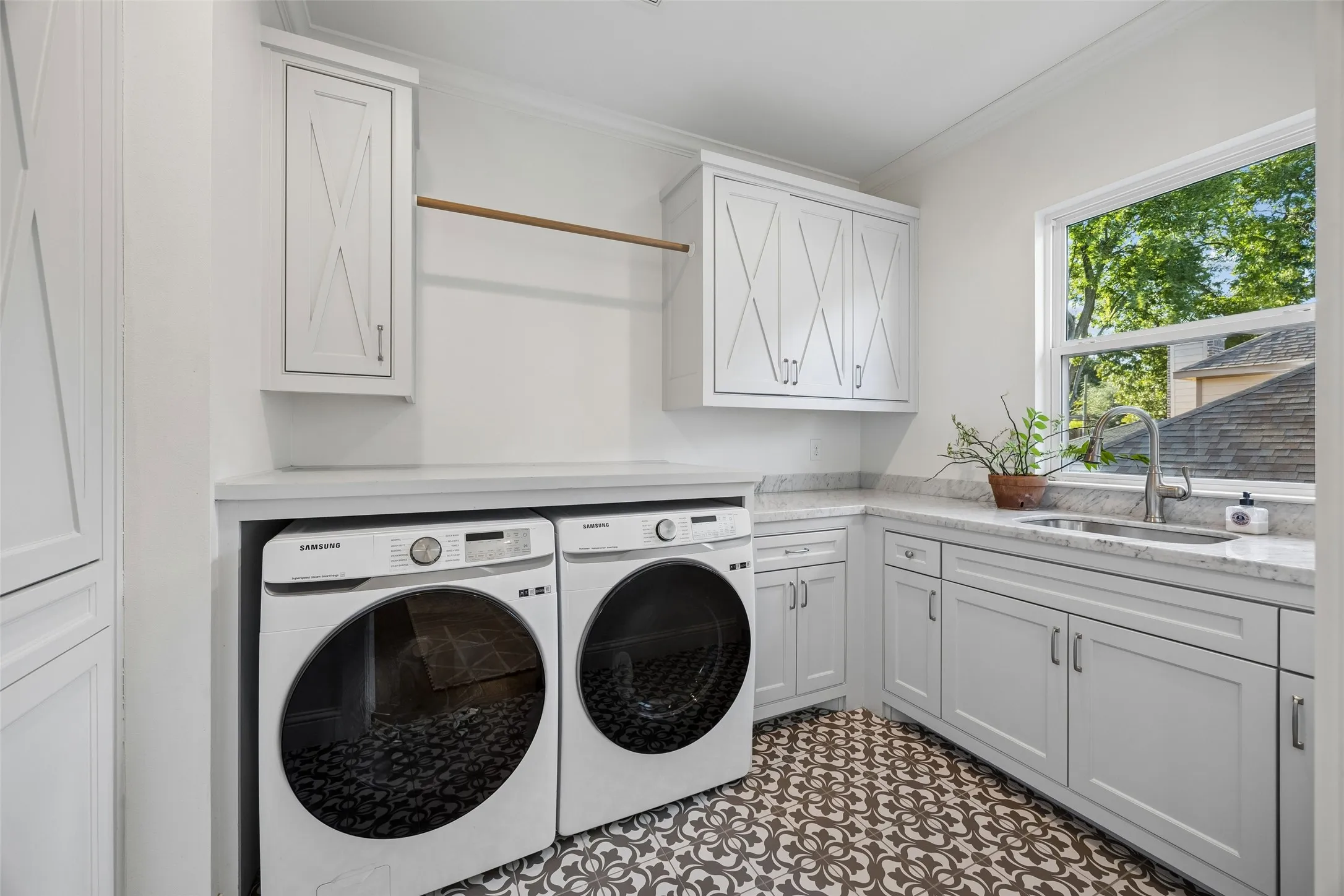 Oversized sized laundry room with numerous plenty of storage cabinets for simple organization, a drip dry area and sink. Conveniently situated near the second floor bedrooms.