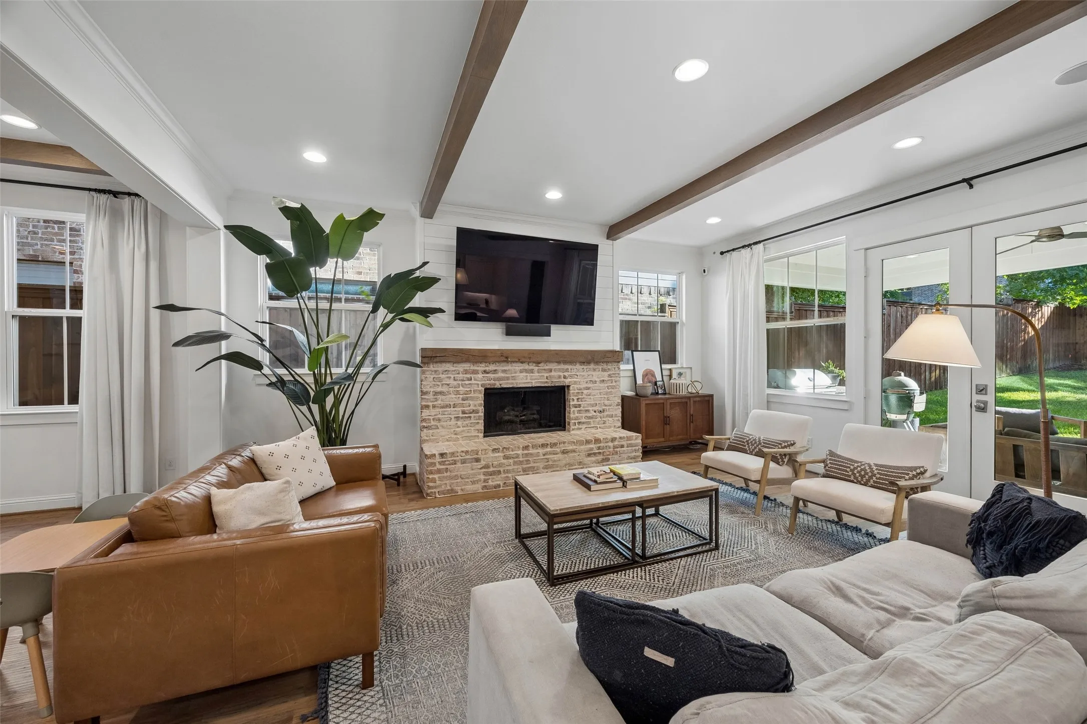 Main floor living room with cozy gas fireplace. French  doors open to the covered rear patio for seamless entertaining