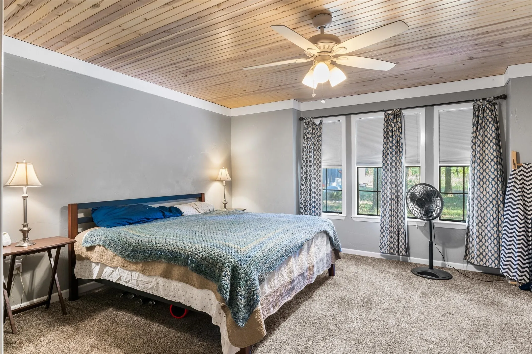 Primary Suite with the continued beadboard ceiling looks out onto the private acreage.