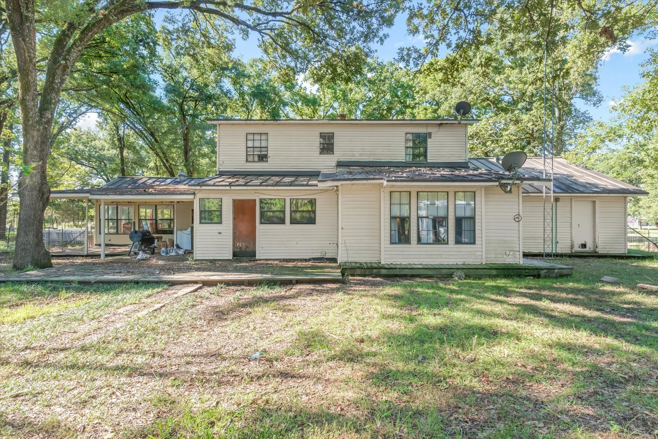 Sunroom & Primary look onto the serene, treed acreage.