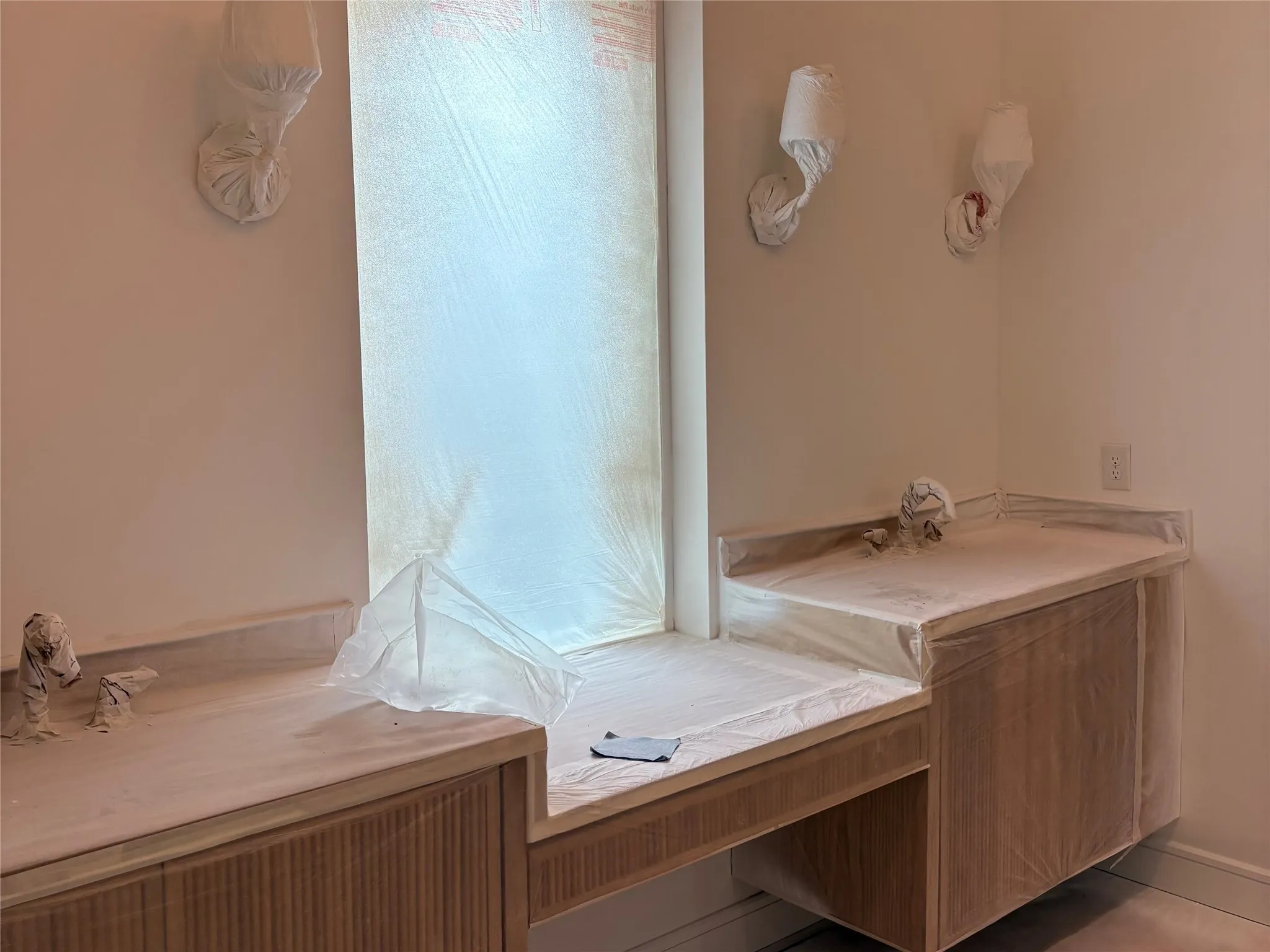 Built-in window seat, integrated vanity cabinetry, sconce lighting, and a window