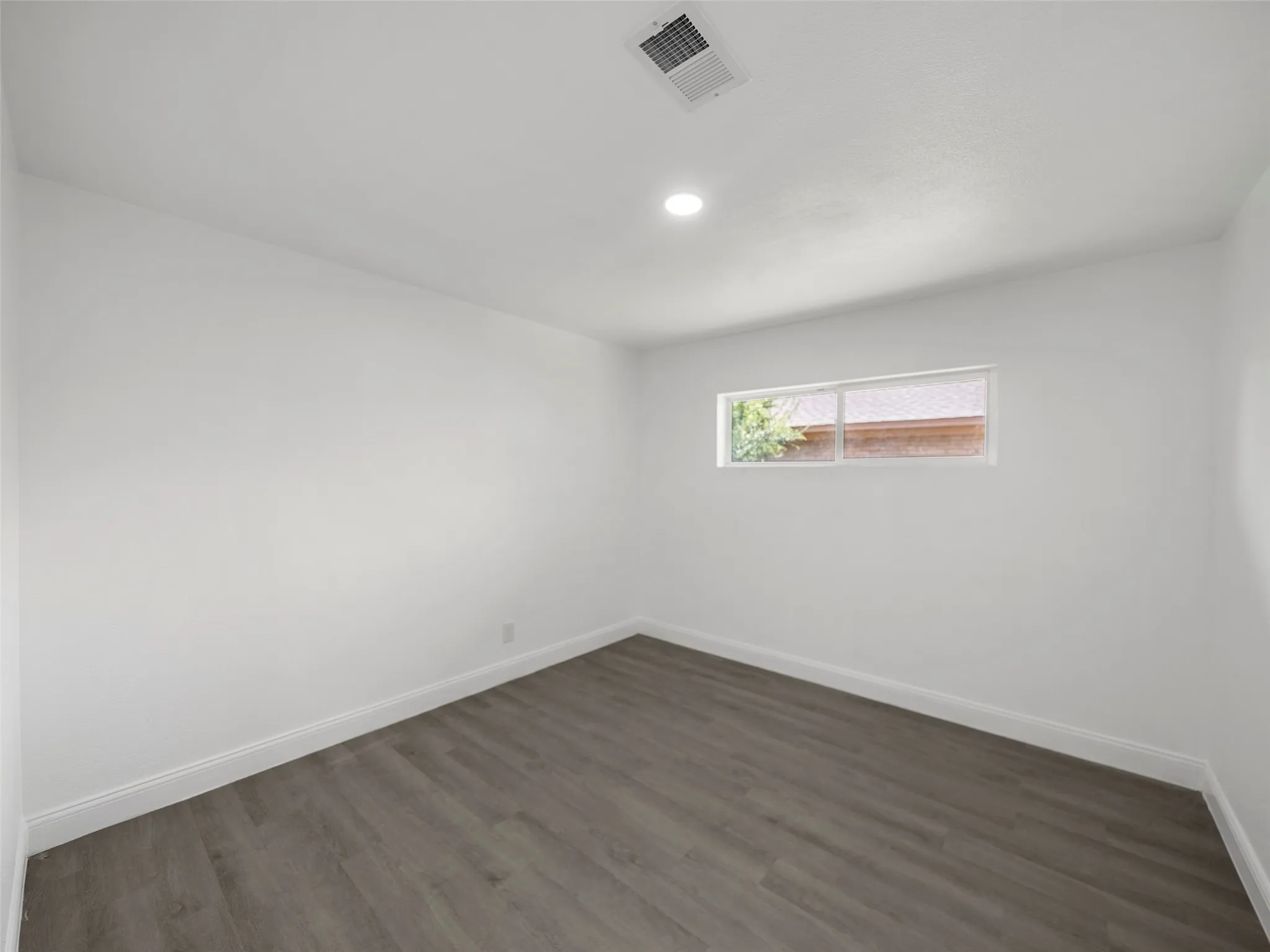 Recessed lighting, wood-finish flooring, white walls, and a horizontal window