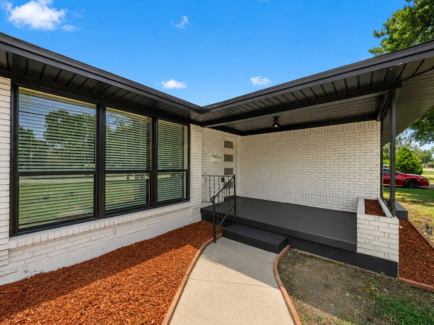 White painted brick exterior with black trim and soffits