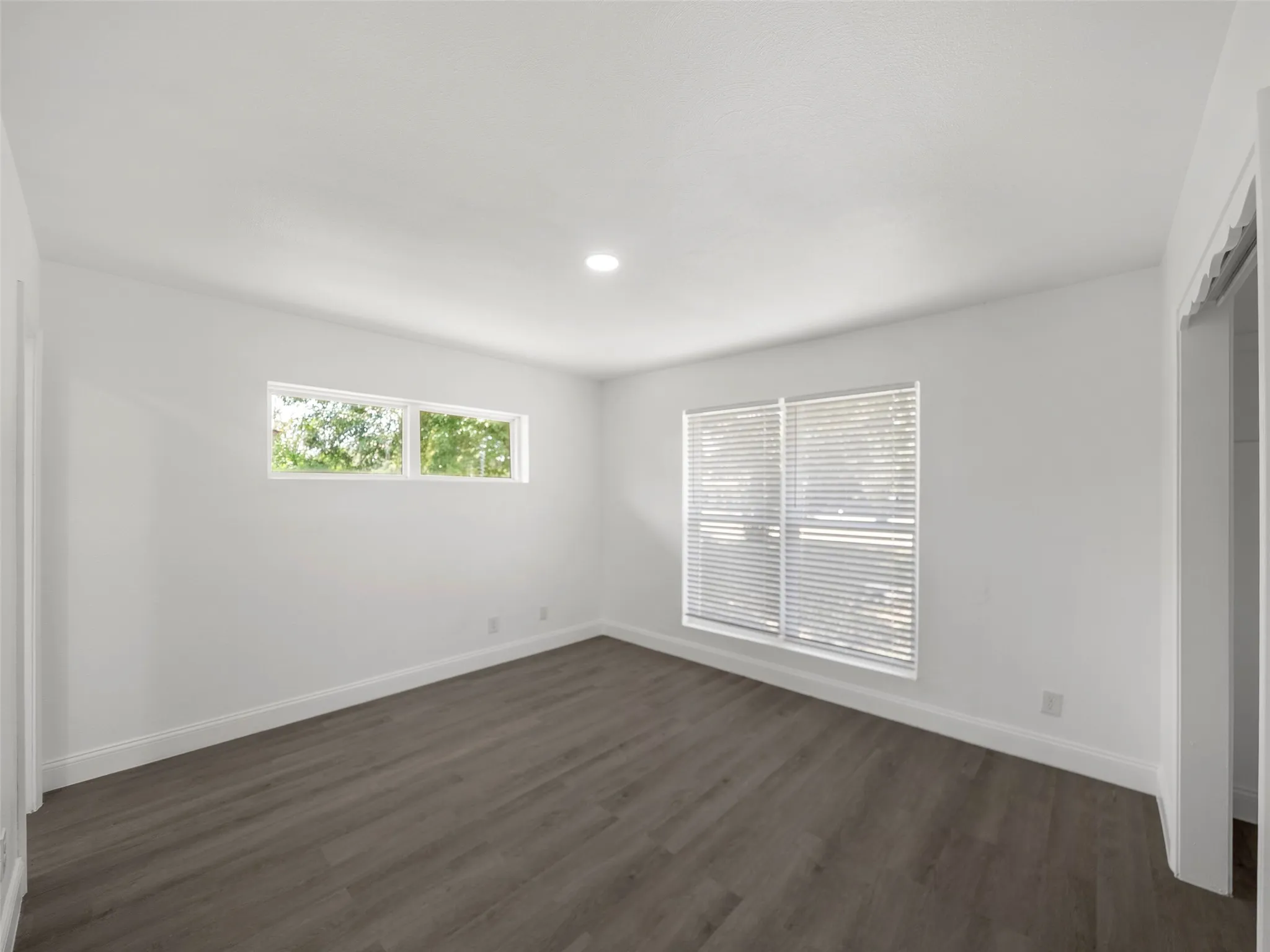 Recessed lighting, wood-finish flooring, white walls, and multiple windows with​​‌​​​​‌​​‌‌​‌‌​​​‌‌​‌​‌​‌​​​‌​​ blinds