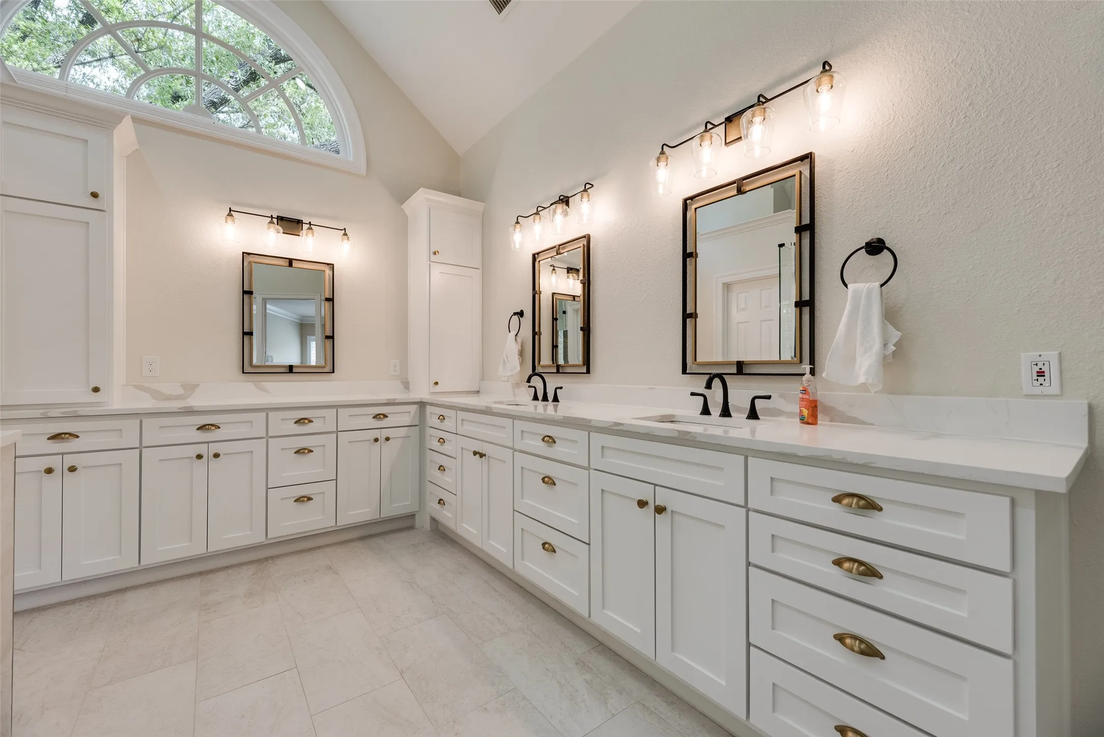 Dual vanity with white cabinetry and gold-tone hardware