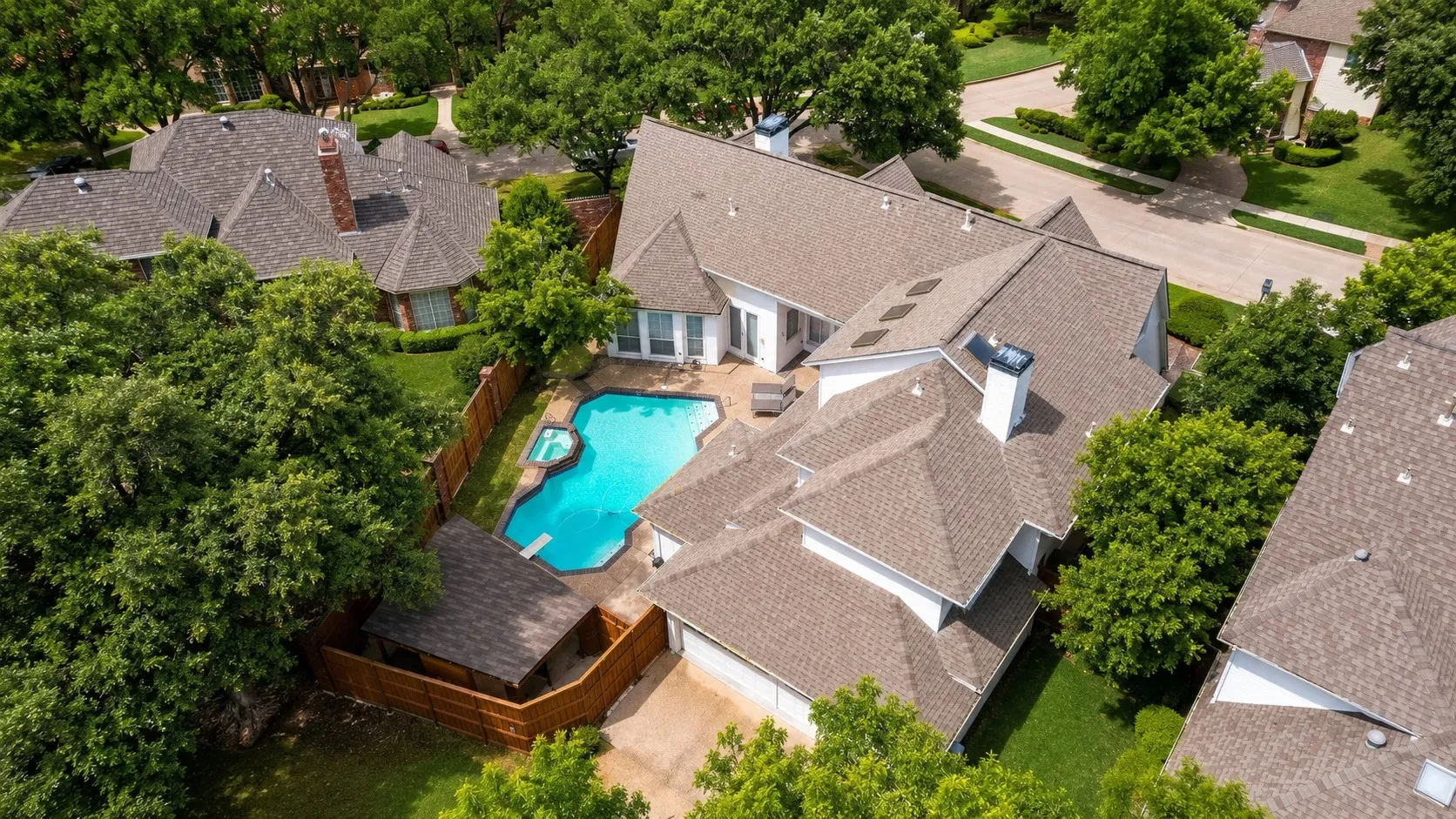 Expansive backyard featuring a swimming pool, integrated spa, diving board, and a fenced perimeter
