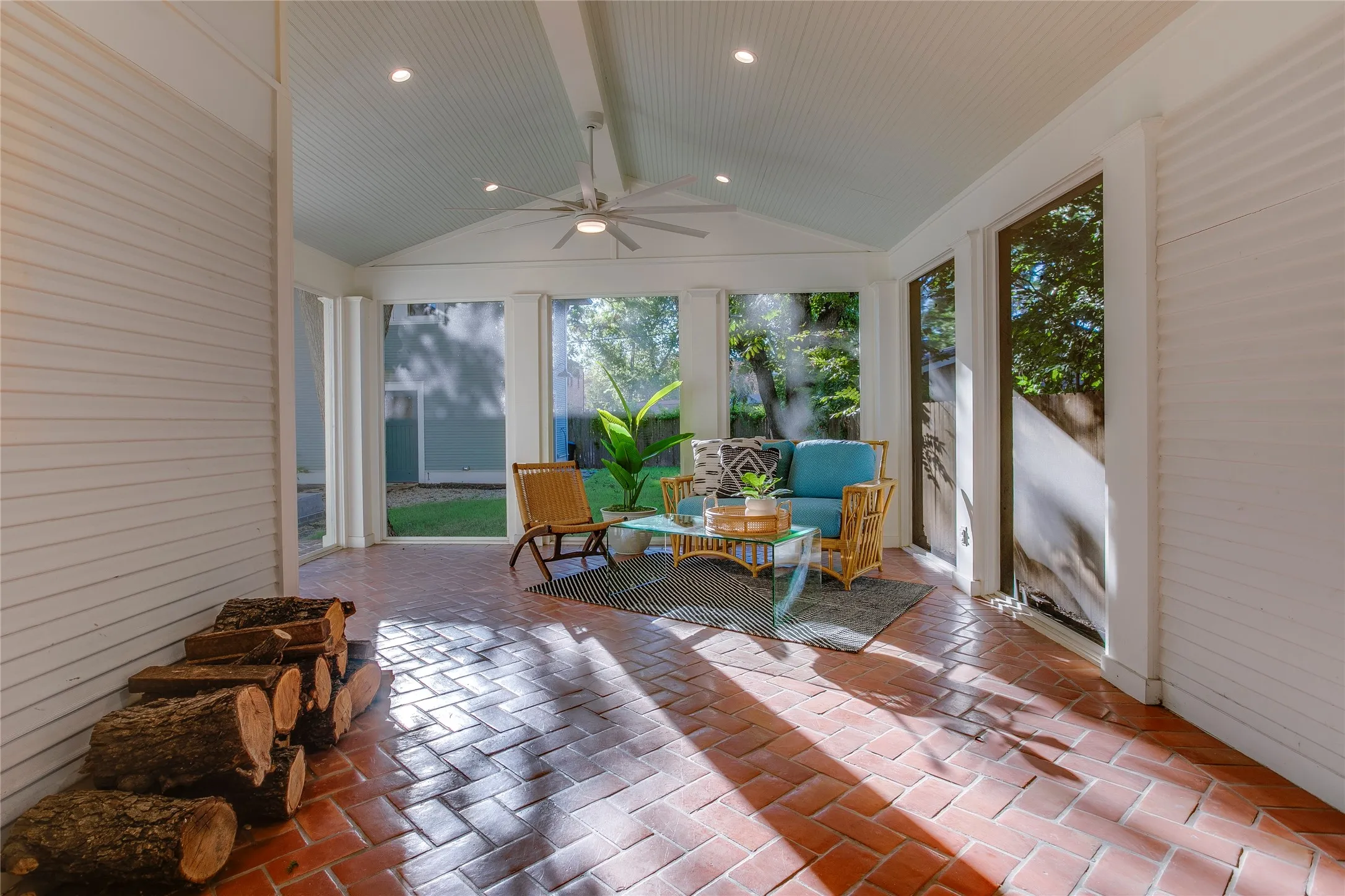 Rear screened porch with Saltillo tile flooring, set in a pretty herringbone pattern, and vaulted ceiling with recessed lighting.