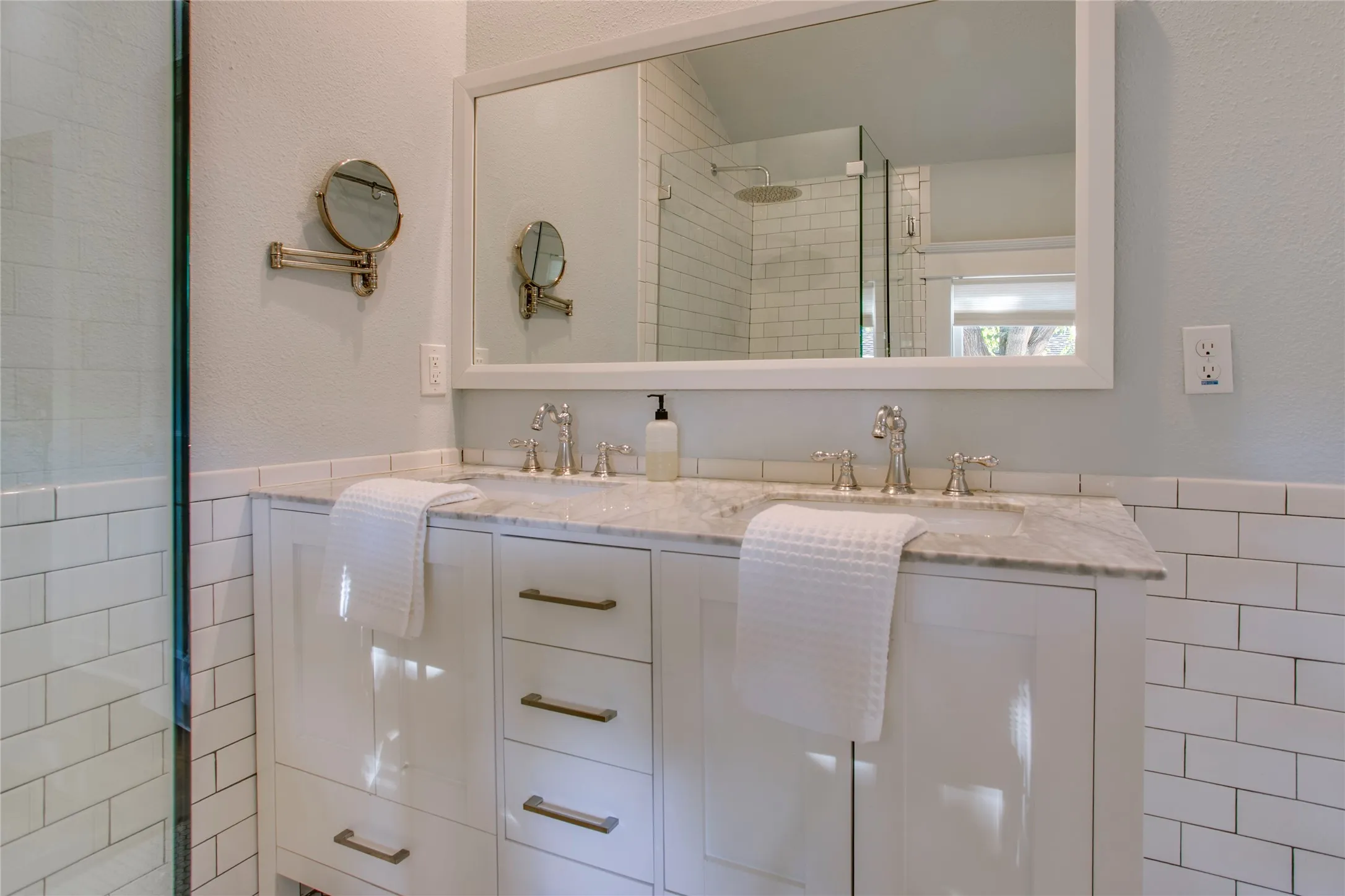 Note the dual sinks and walk-in glass shower