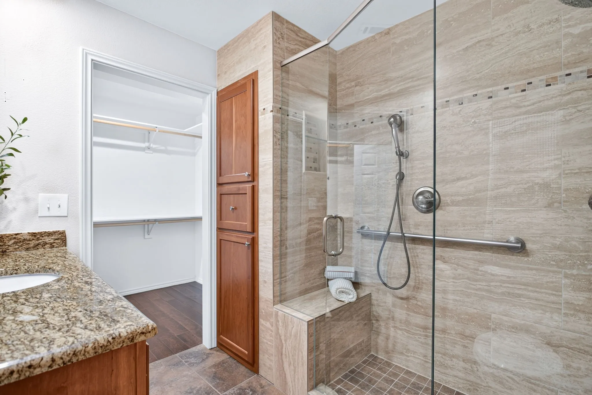 The walk-in shower includes multiple toiletry nooks, a bench seat, hand-held showering wand - and check out all the extra custom storage.