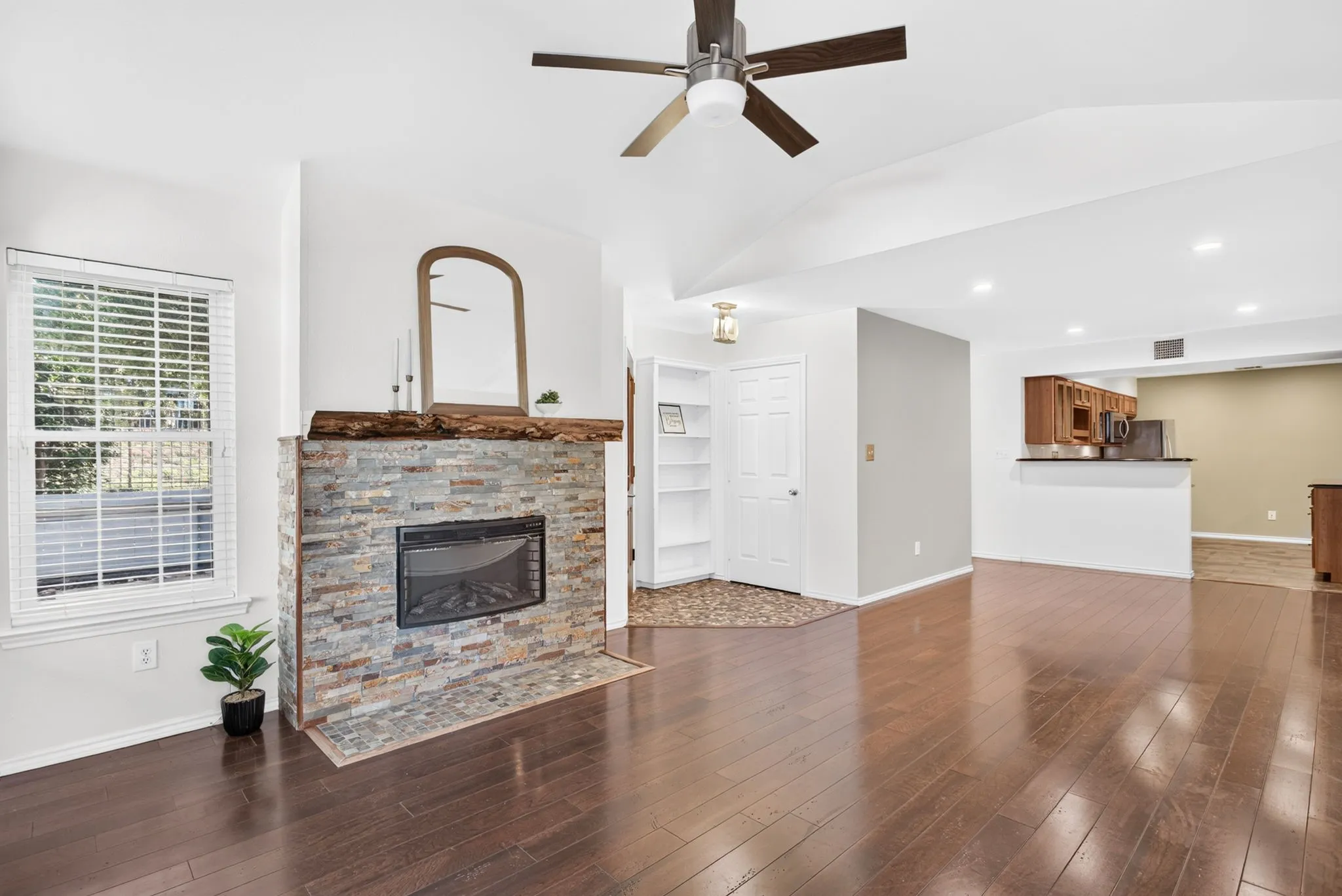 Hardwood floors flow through this space, into the hallway, into the primary suite and up the stairs.