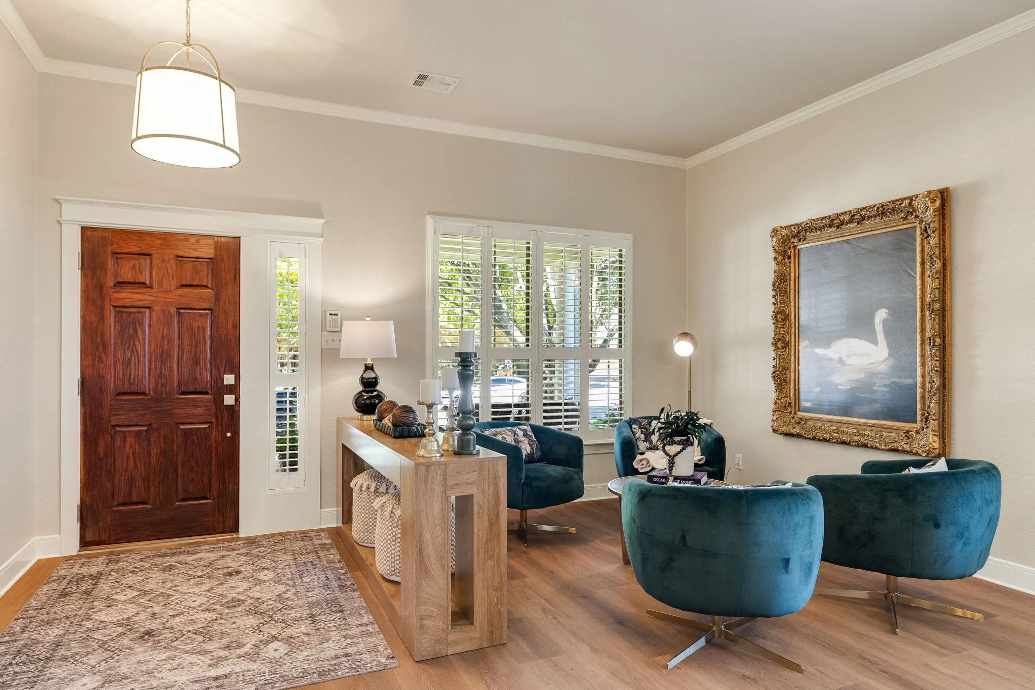 Wood-finish flooring, crown molding, and a solid wood entry door with sidelight