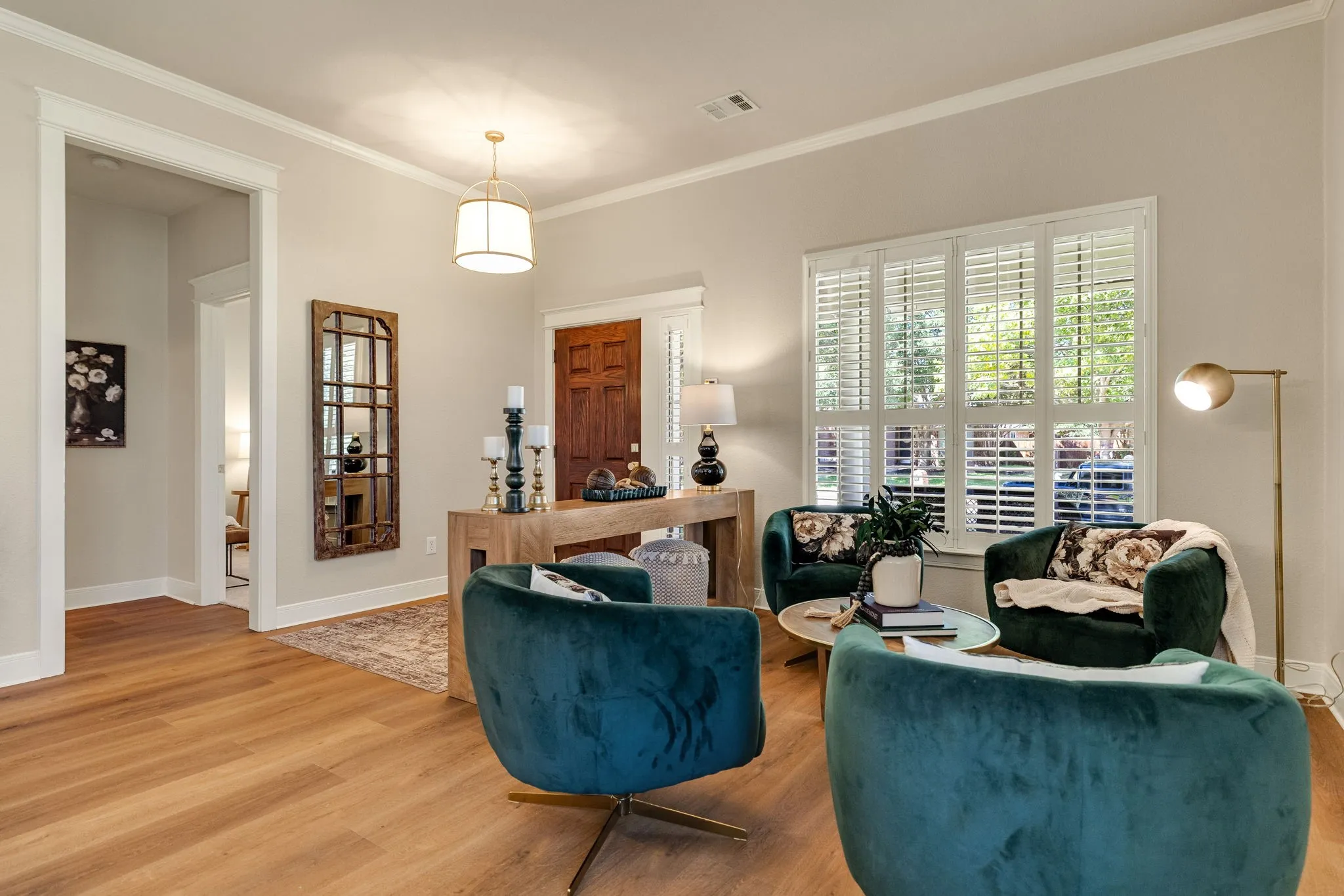 Light wood-finish flooring with white baseboards and crown molding