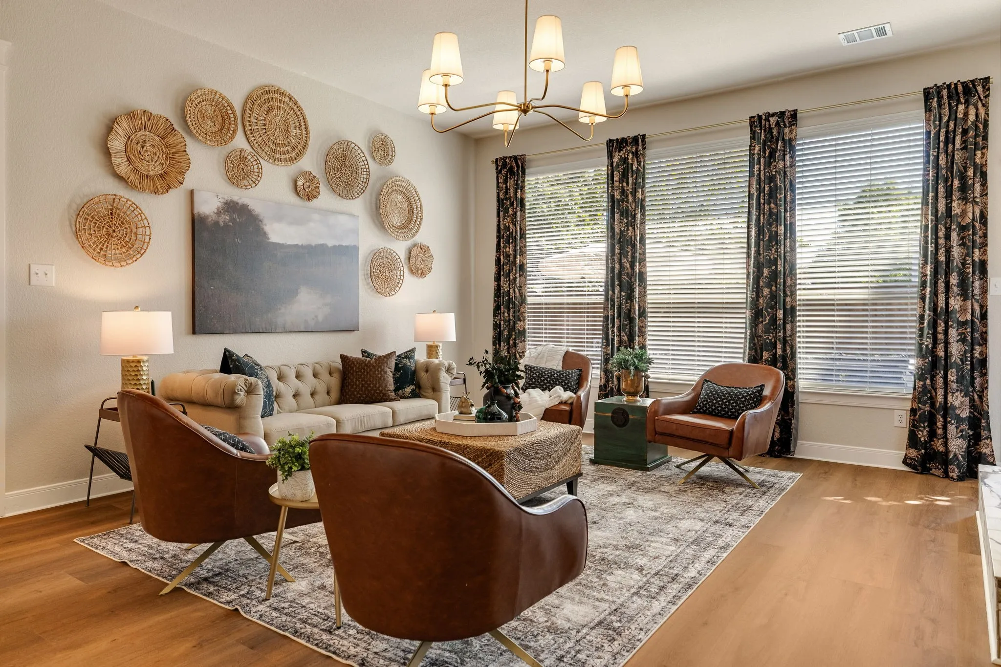 Bright living area featuring wood-finish flooring, multiple windows, and a multi-arm ceiling light fixture