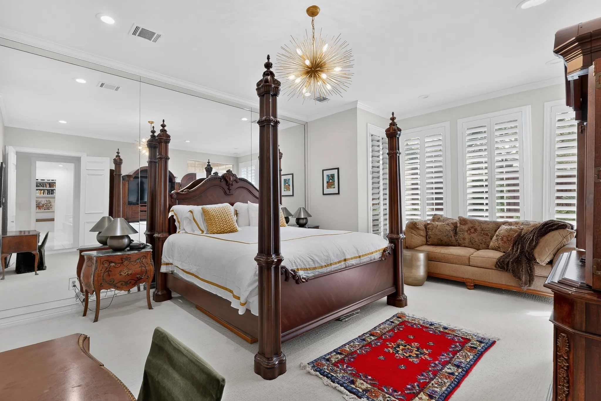 Wall-to-wall carpeting, crown molding, plantation shutters, and a modern sputnik chandelier