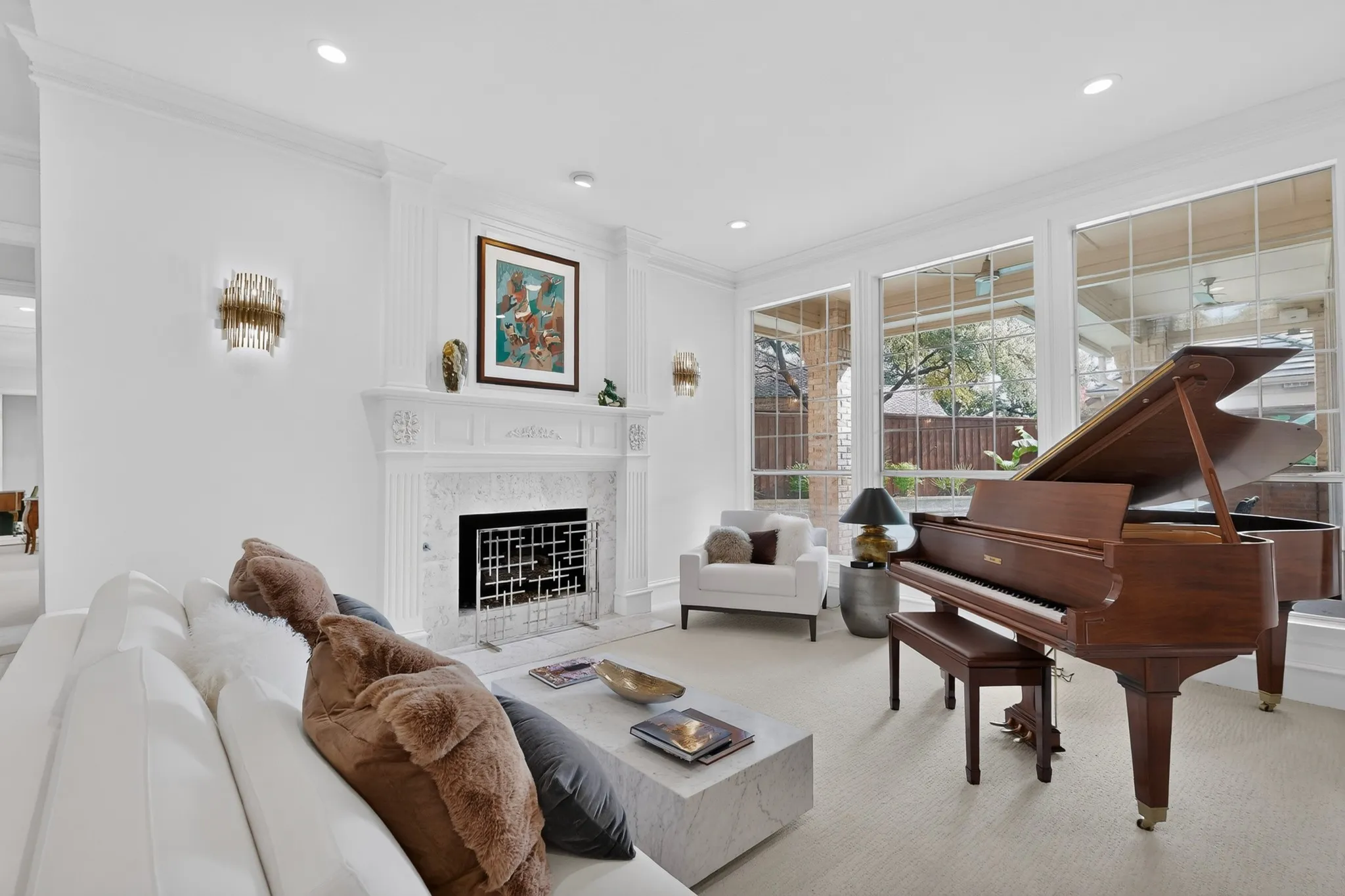 Living area featuring a detailed fireplace with a marble surround, large windows, and recessed lighting