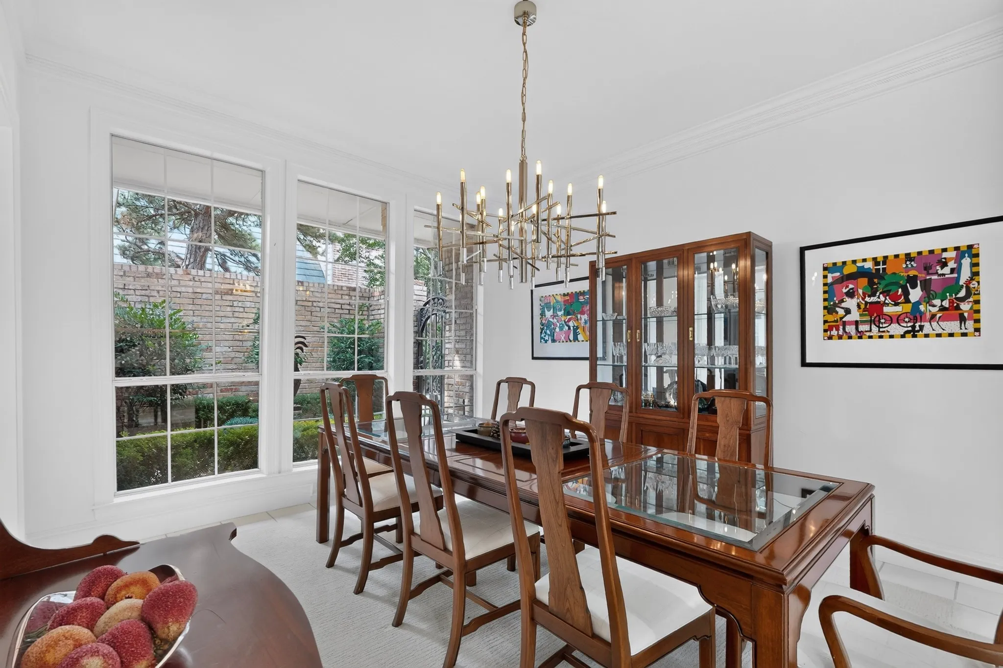 Multiple large windows with white trim, contemporary chandelier, crown molding, and light-toned flooring