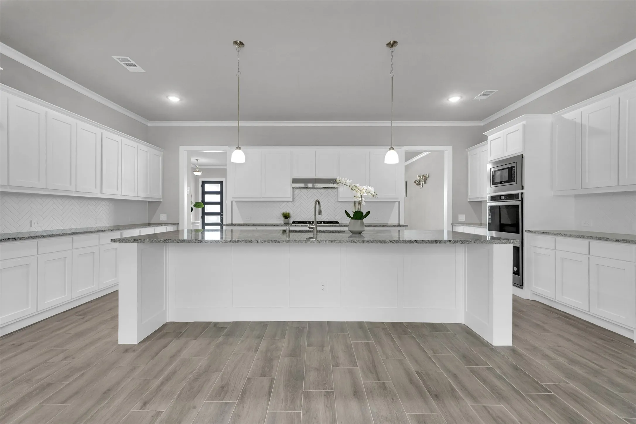 Spacious kitchen with granite countertops, double oven, large island, and custom cabinetry—ideal for entertaining