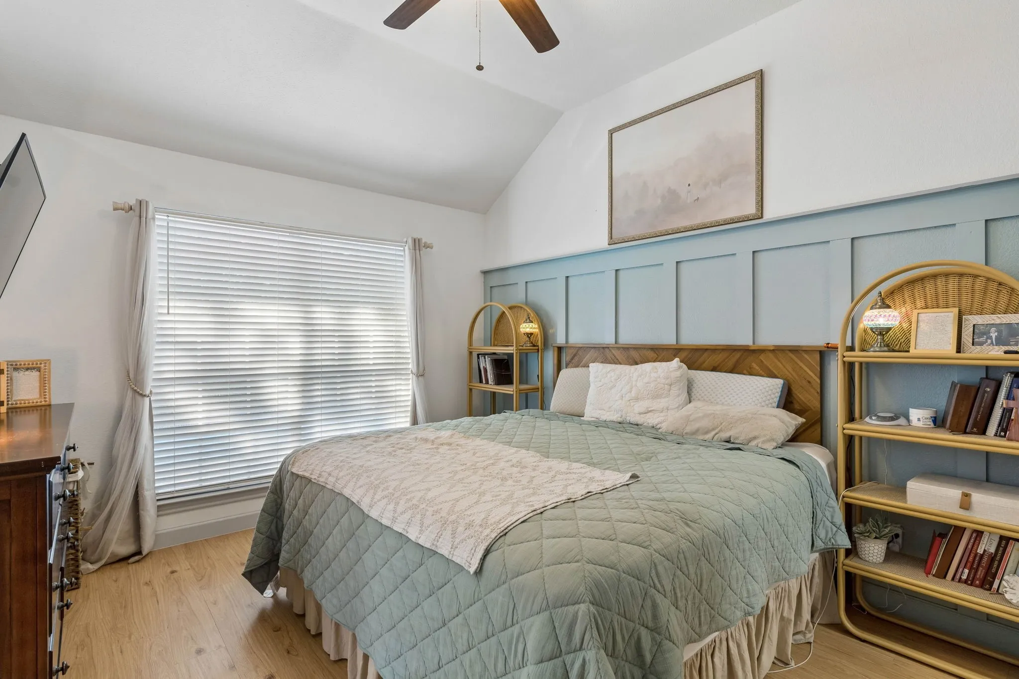 Another view of the primary bedroom displaying, the beautiful wainscotting, and the large window for lots of natural light.
