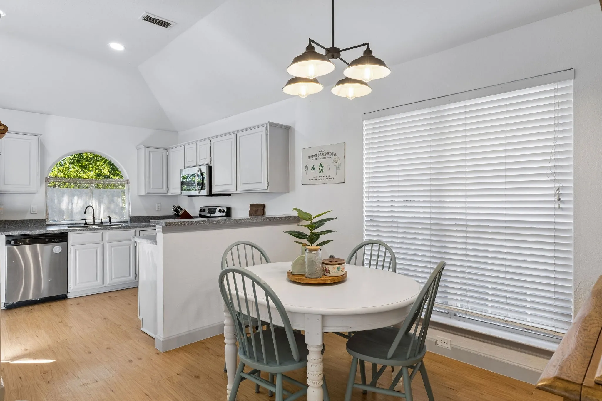 The view of the dining area flowing seamlessly into the kitchen and the large window to give lots of natural light.