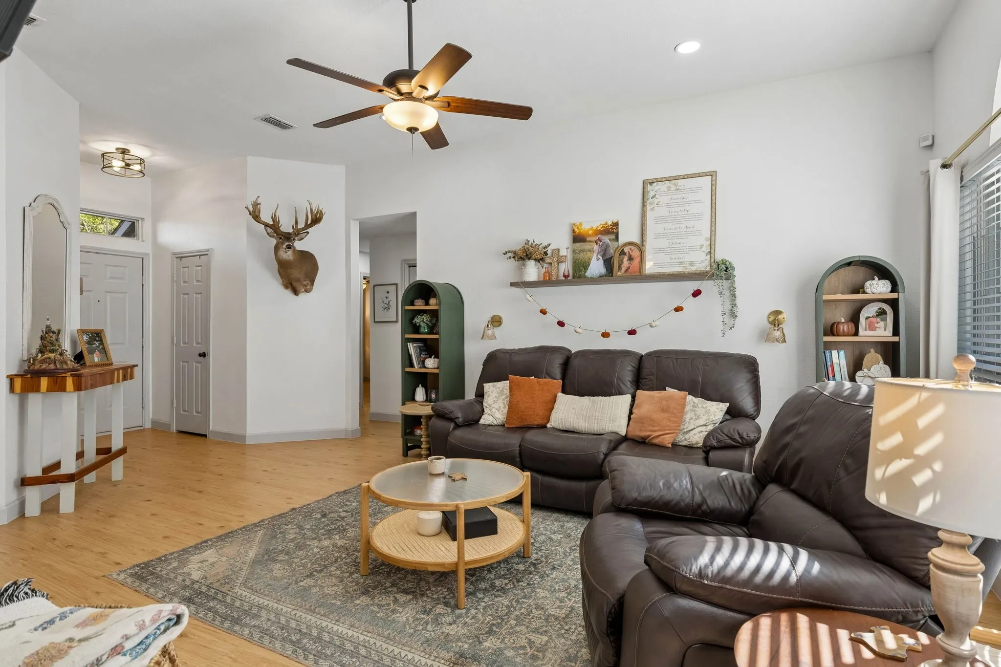 This view of the living shows the entryway and the entrance to the secondary and primary bedrooms.