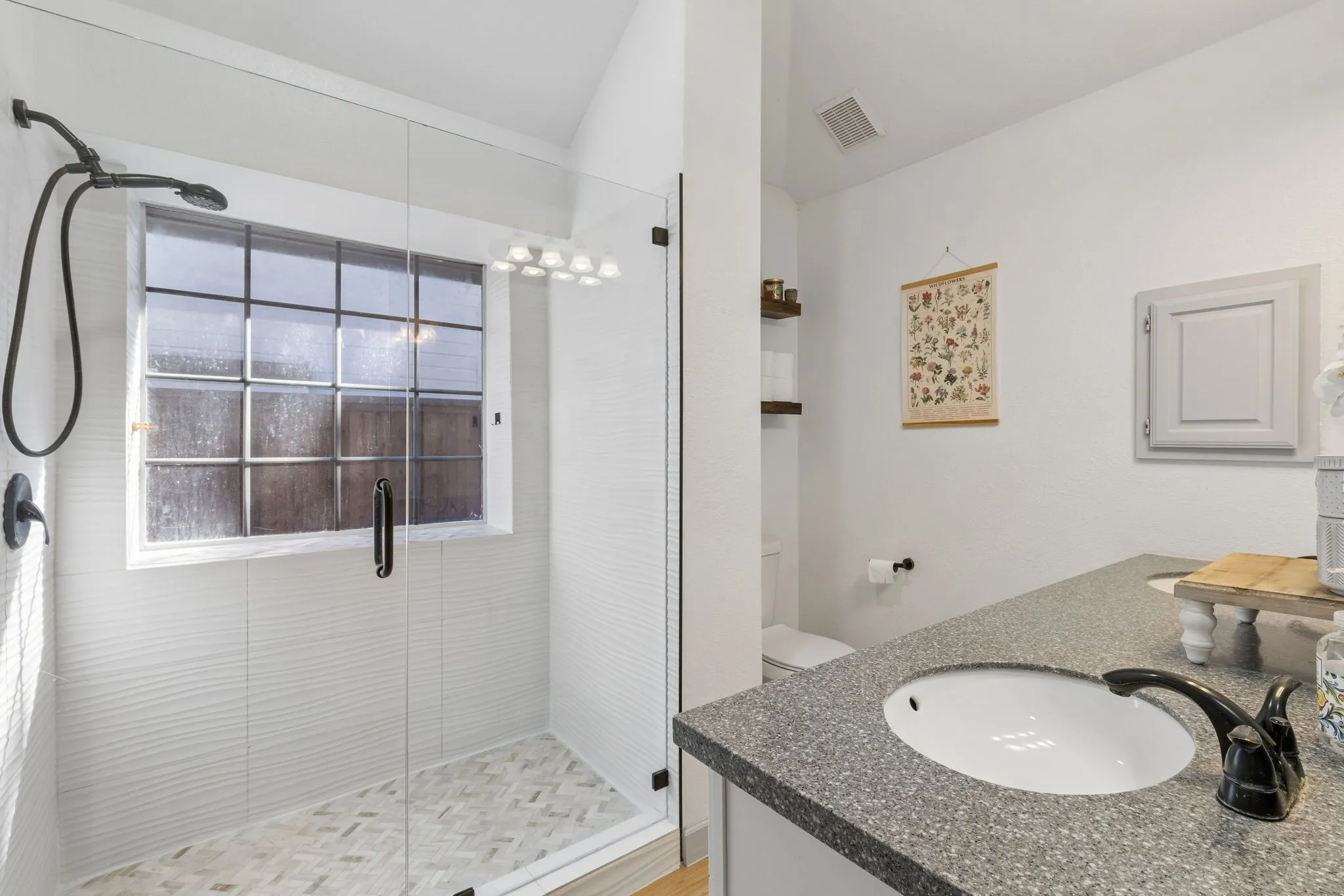 As you enter the the primary bathroom, you will see a large updated walk-in shower and LVP flooring.