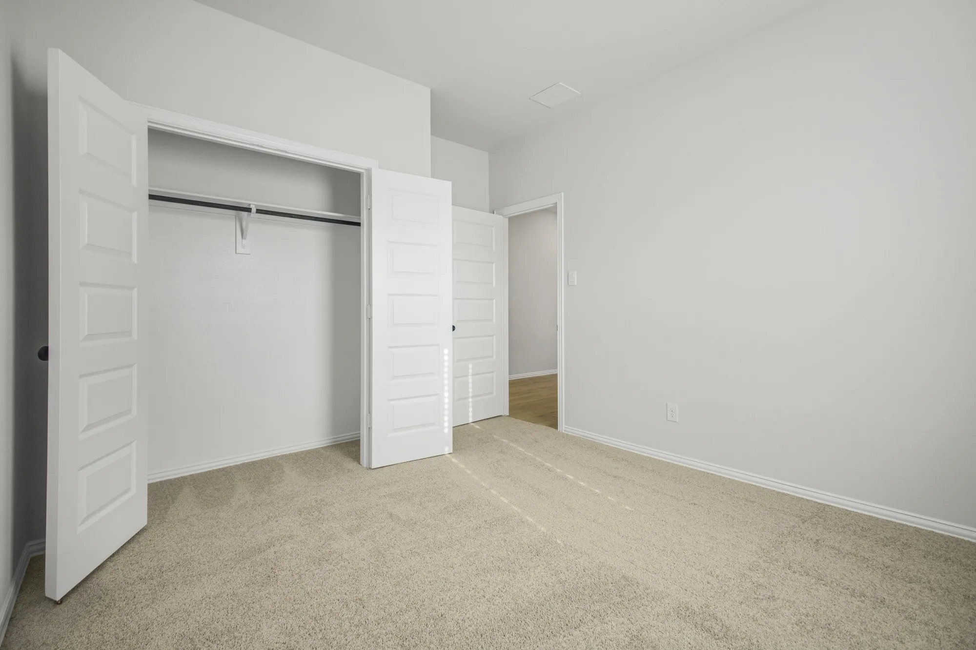 Neutral-toned carpet flooring and white walls