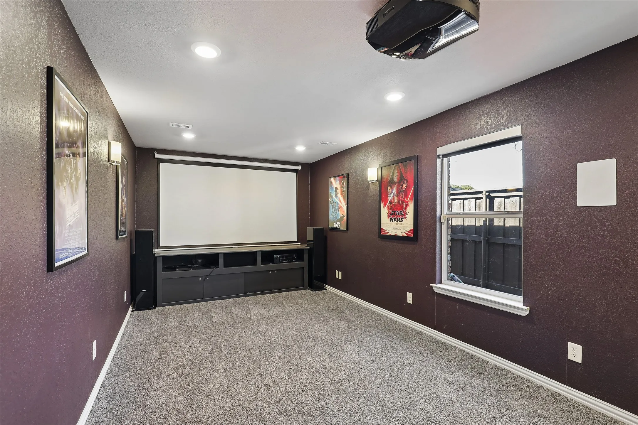 -in projector, wall-mounted screen, recessed lighting, wall sconces, and built-in media console