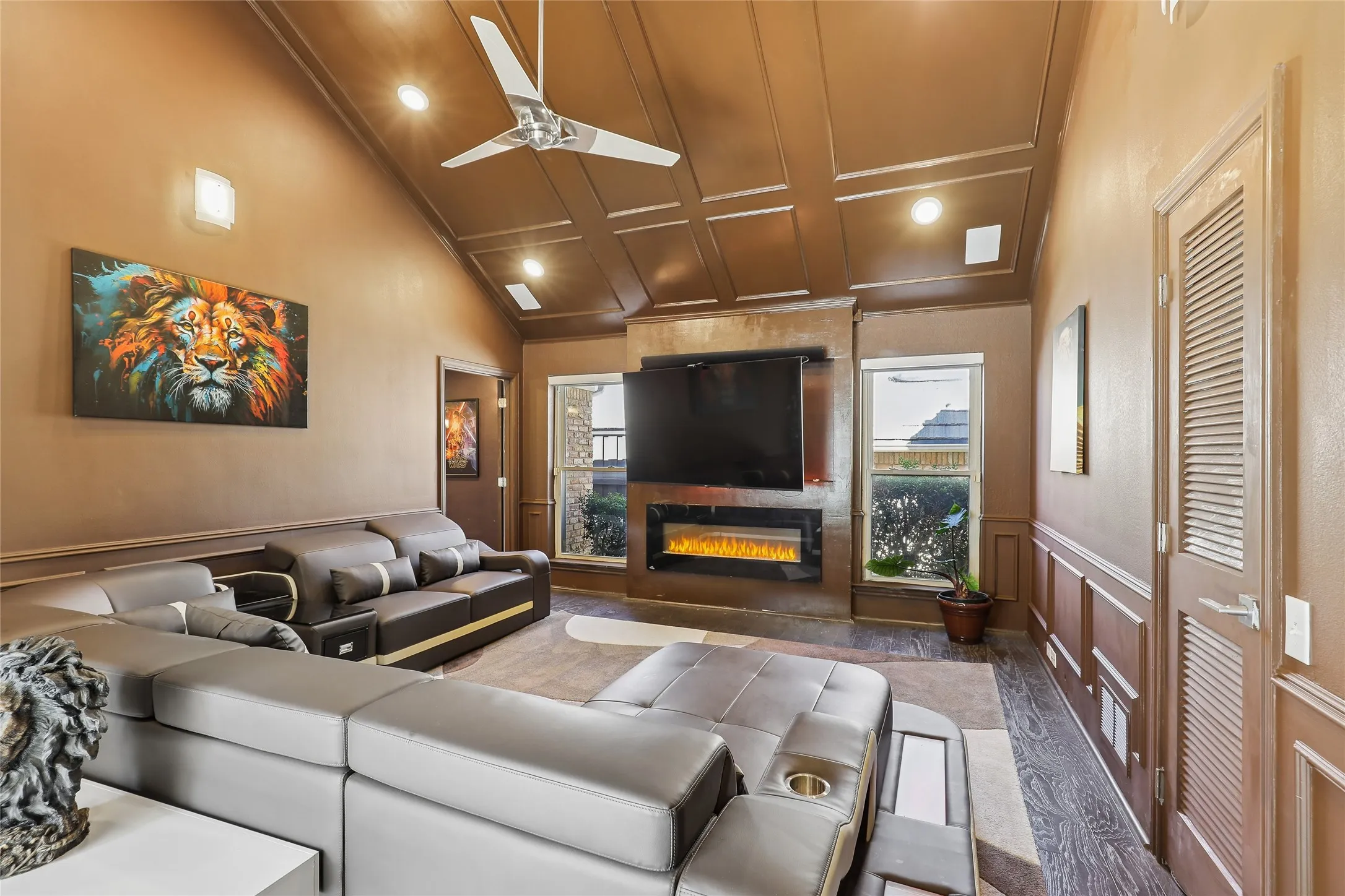 Vaulted ceiling with recessed lighting, electric fireplace, and a modern ceiling fan