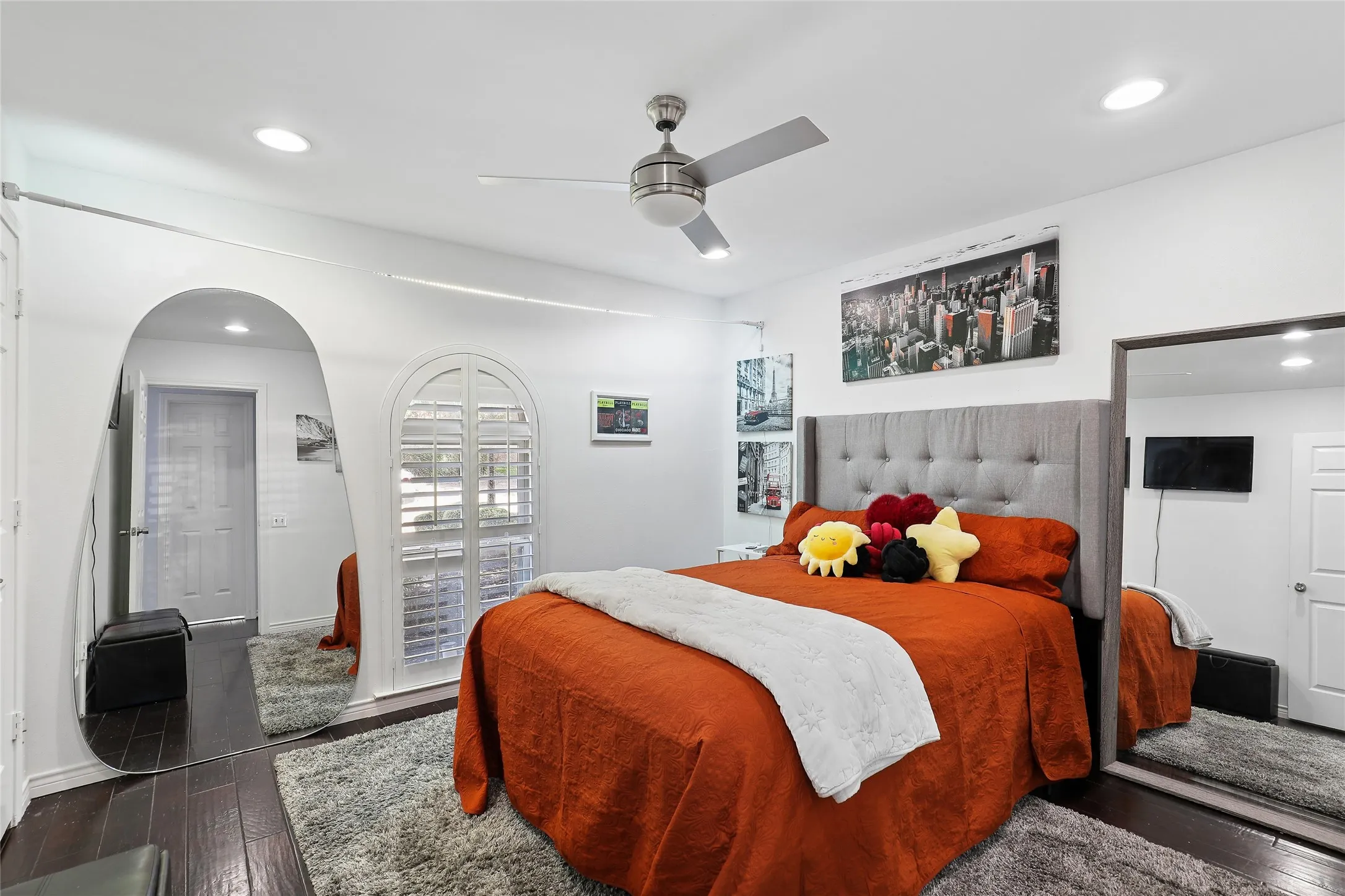 Jack and Jill ensuite.  Recessed lighting, ceiling fan, dark wood-finish flooring, arched doorway, and plantation shutters