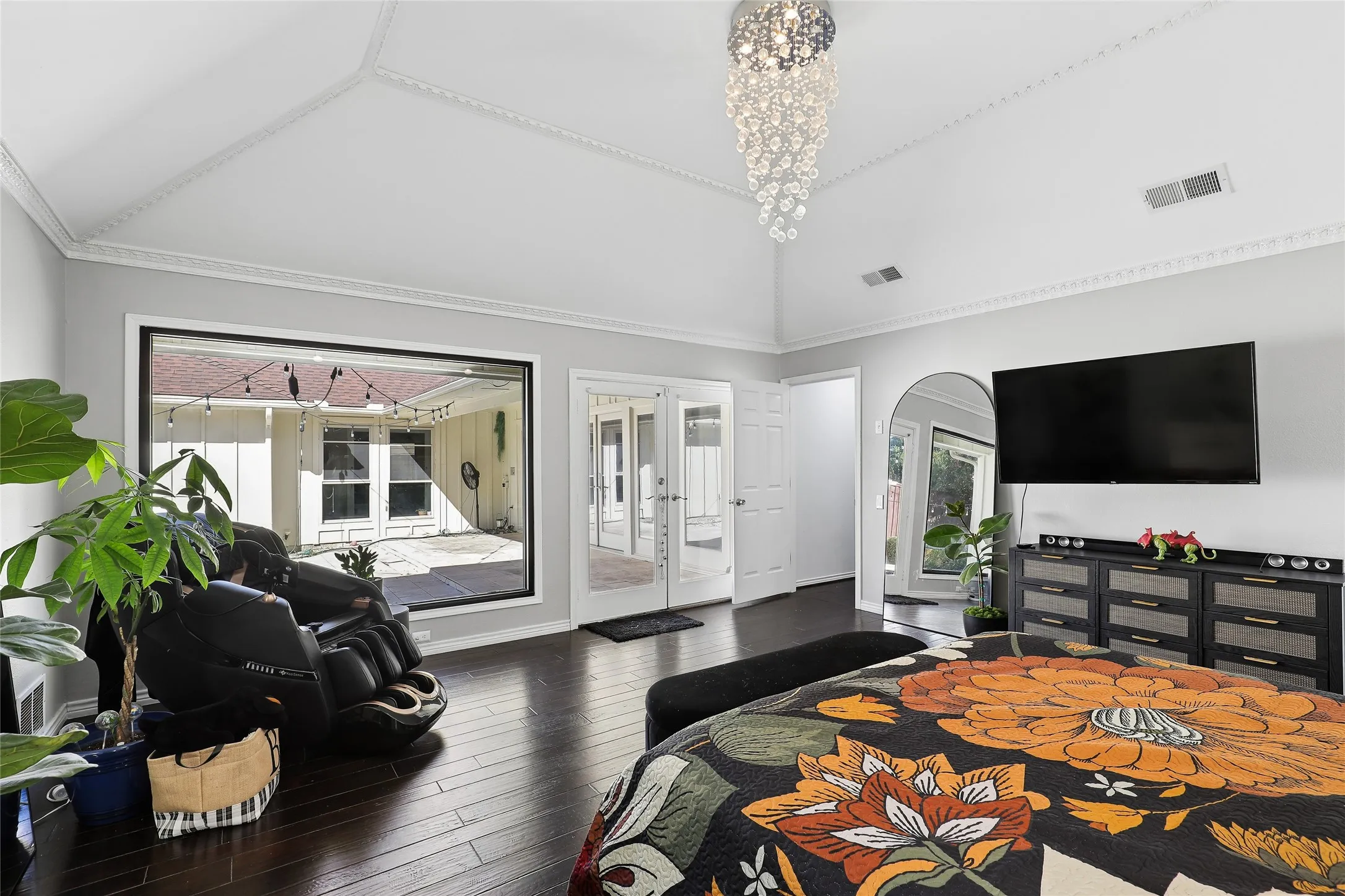 Oversized fish-bowl window allows for abundant light.  The adjoining double glass doors   Vaulted ceiling with crown molding, dark wood-finish flooring, large picture window, and double French doors opening to the patio offer quick access to the pool and spa.