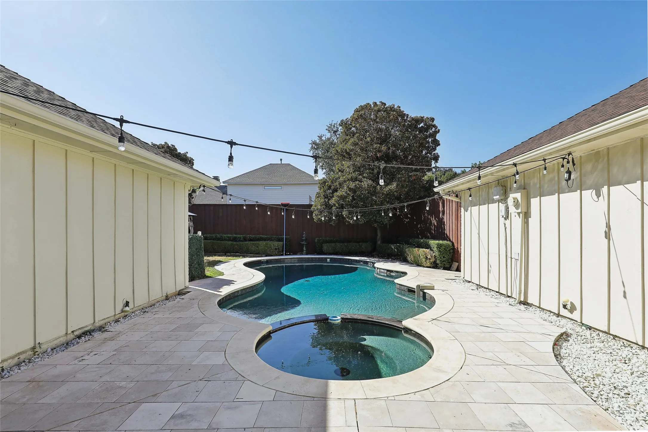 Private backyard featuring a free-form pool with an integrated spa