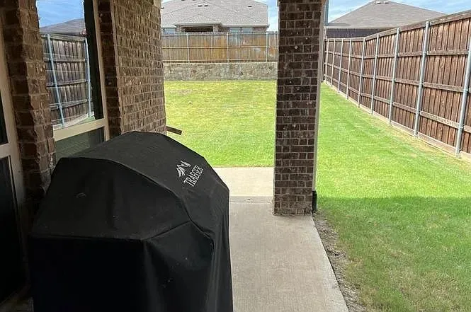 Covered patio with brick columns and a concrete surface